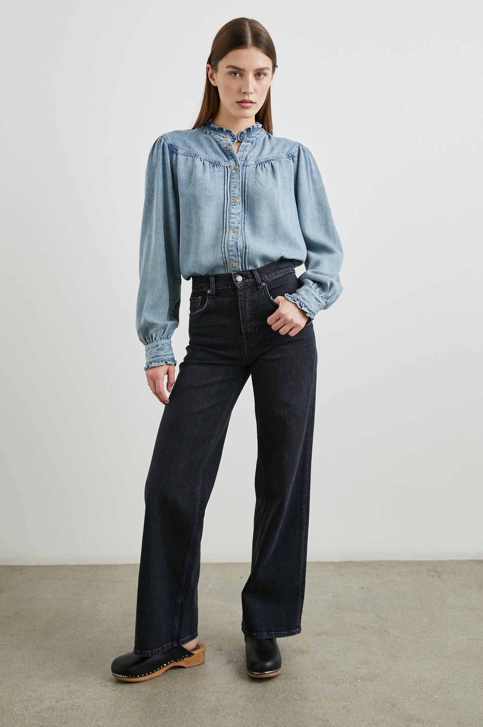Alanna Long Sleeve Shirt with Snaps Down the Front, a Ruffled Collar, Banded Ruffed Cuffs, and Pleats at the Yoke Seam in Antique Indigo Colorway - Front Tucked View Full Body Featured on Model