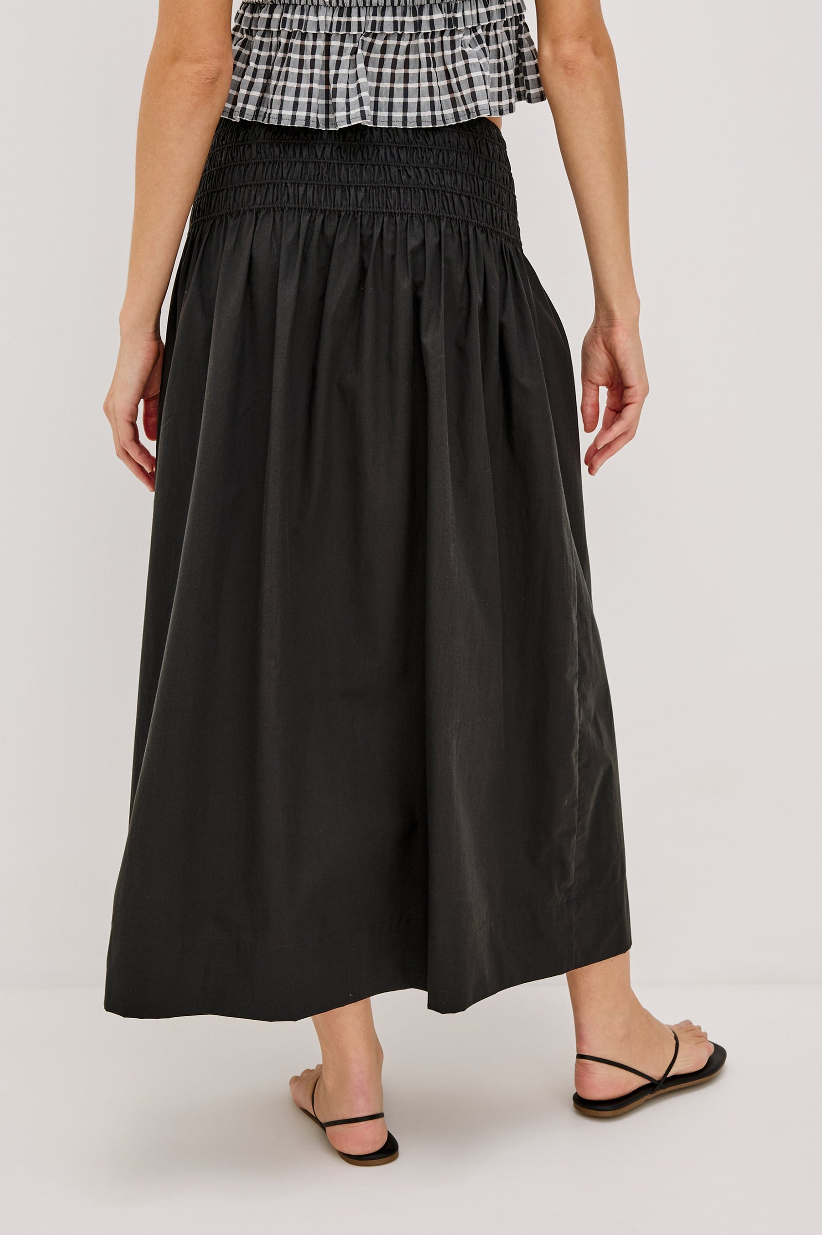 Alessa Midi Skirt with a Wide Elastic Gathered Waistband in Black Colorway. Back View Shown on Model.