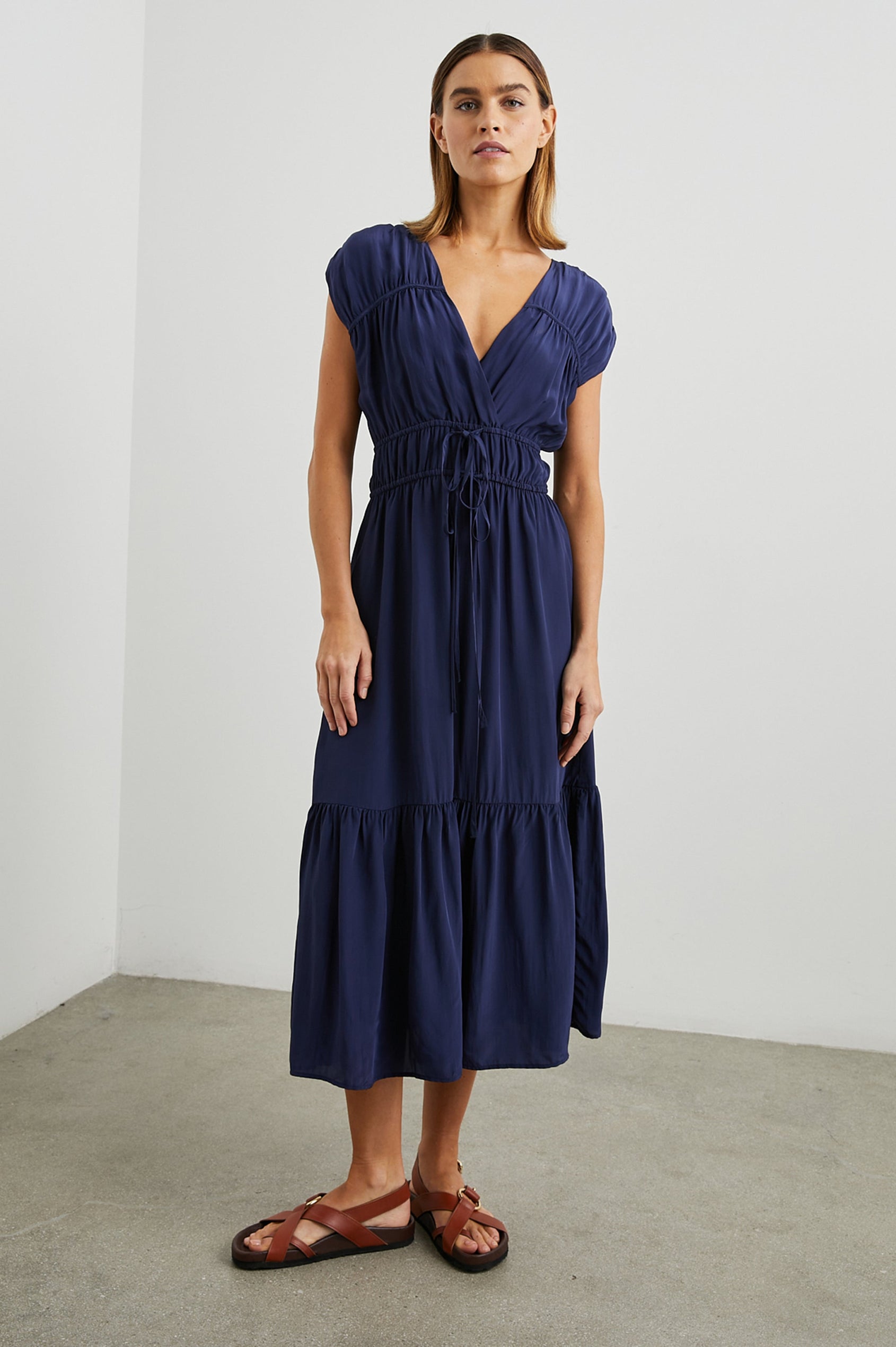 Aletta Short Sleeve Midi Dress with Cap Sleeves with Wide Arm Holes, Two Drawstrings at the Waist, a Deep V Neck, a Tiered Skirt and Ruching at the Front Yoke Seam and Shoulder Seam in Admiral Blue Colorway - Front Full Body View Featured on Model