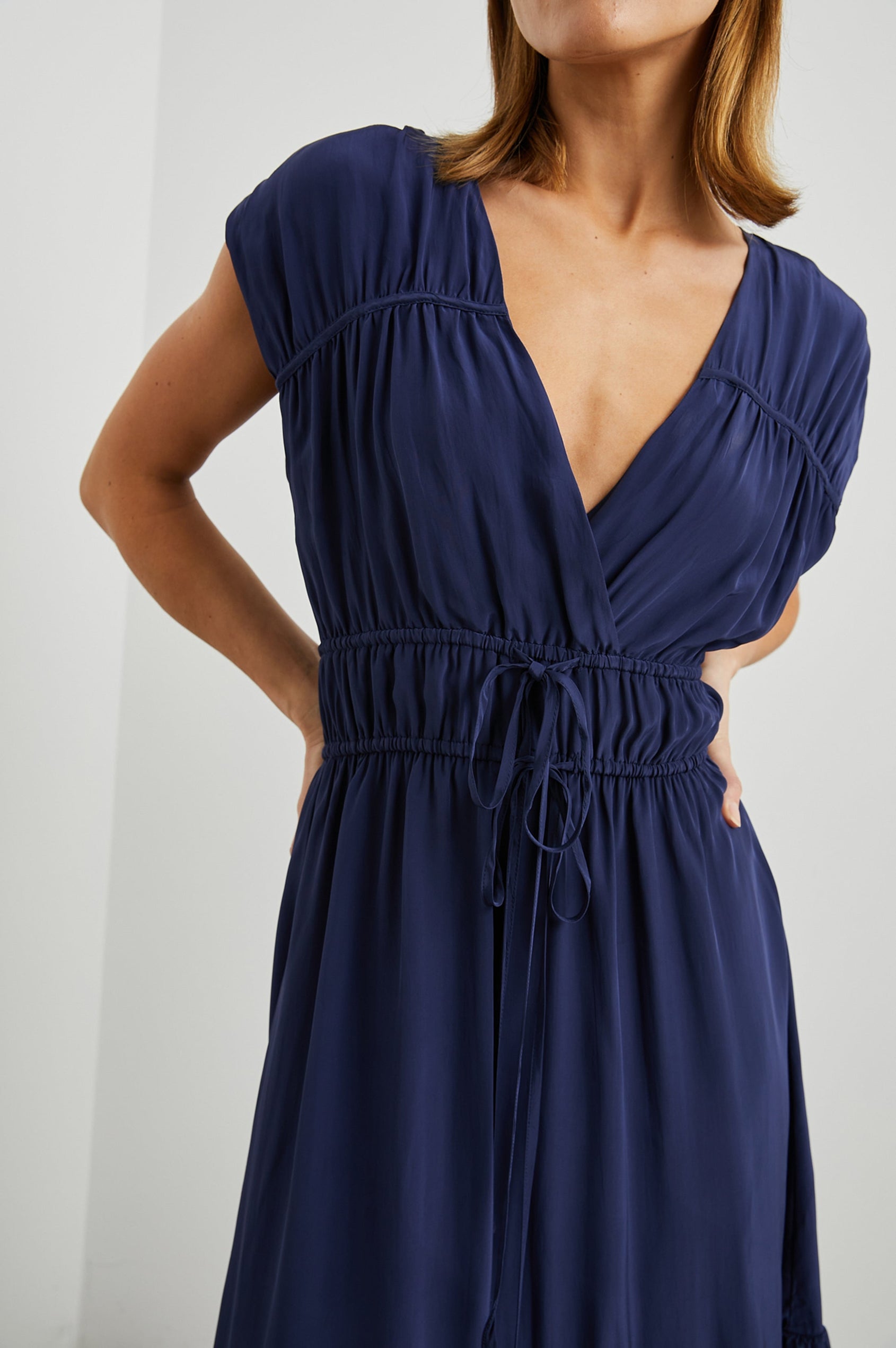 Aletta Short Sleeve Midi Dress with Cap Sleeves with Wide Arm Holes, Two Drawstrings at the Waist, a Deep V Neck, a Tiered Skirt and Ruching at the Front Yoke Seam and Shoulder Seam in Admiral Blue Colorway - Front View Featured on Model