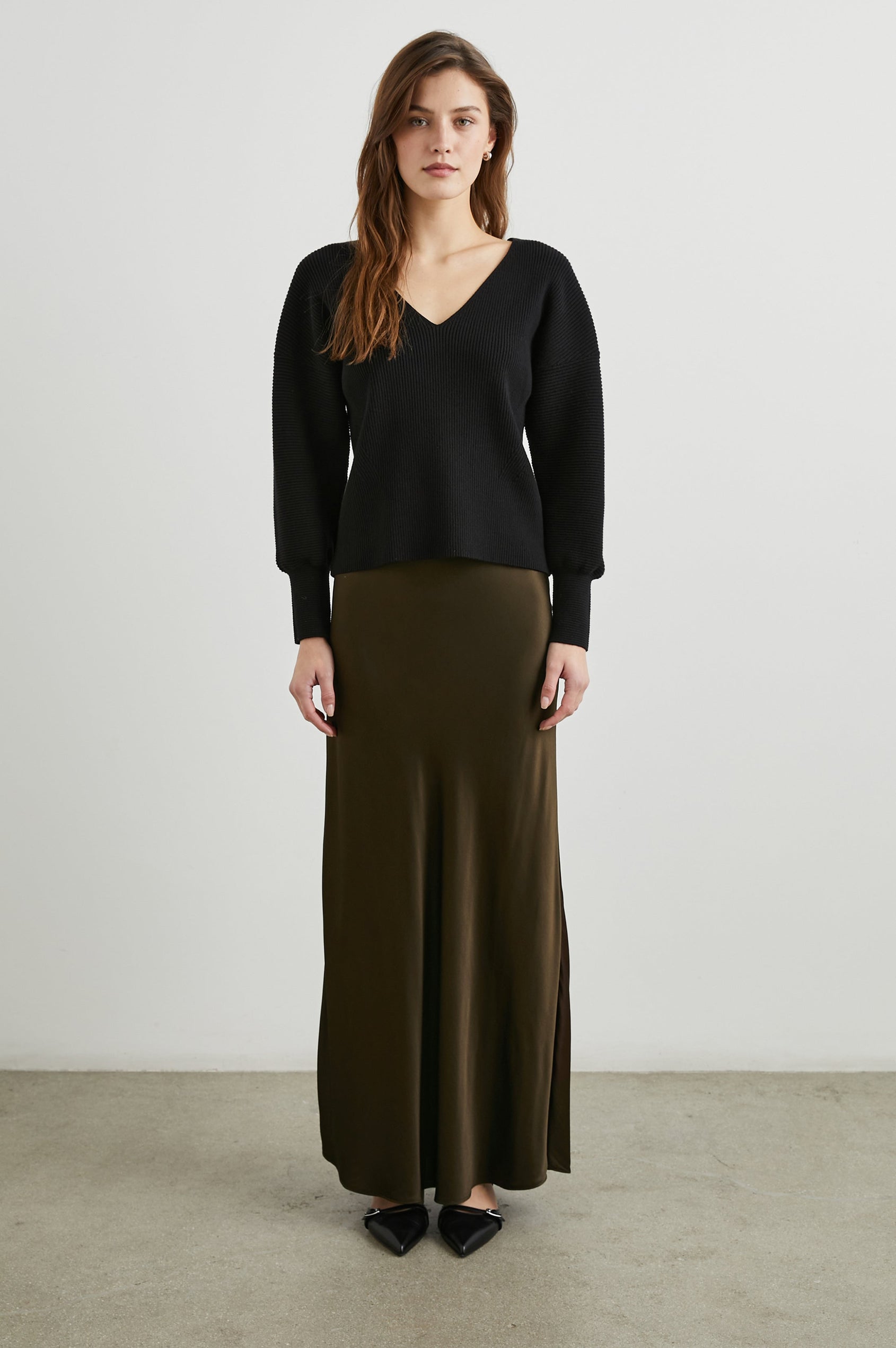 Alondra Ribbed Long-Sleeve Sweater with a Deep V Neck and Puff Sleeves in Black Colorway - Front Full Body View Featured on Model