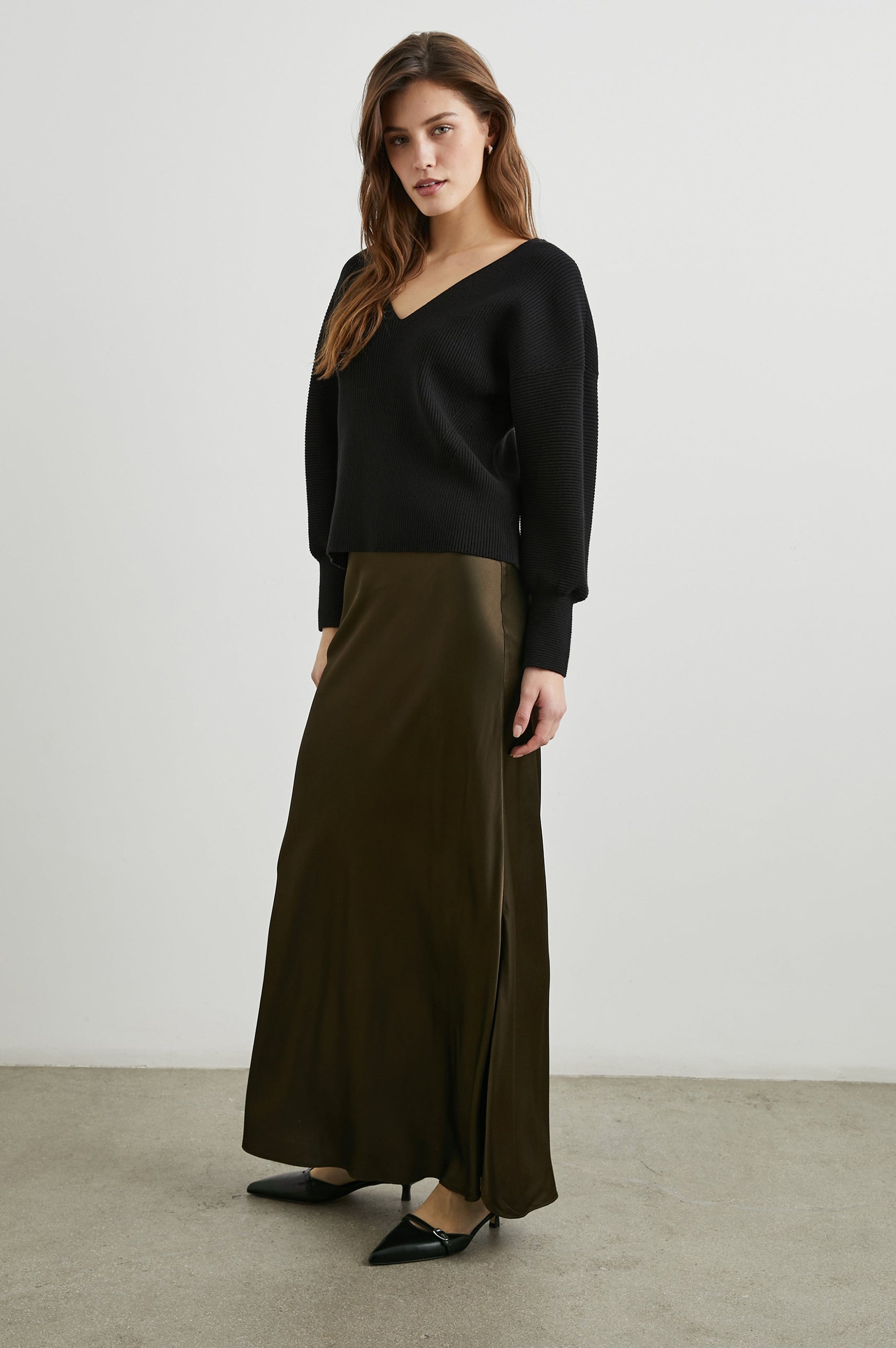 Alondra Ribbed Long-Sleeve Sweater with a Deep V Neck and Puff Sleeves in Black Colorway - Front Full Body View Featured on Model