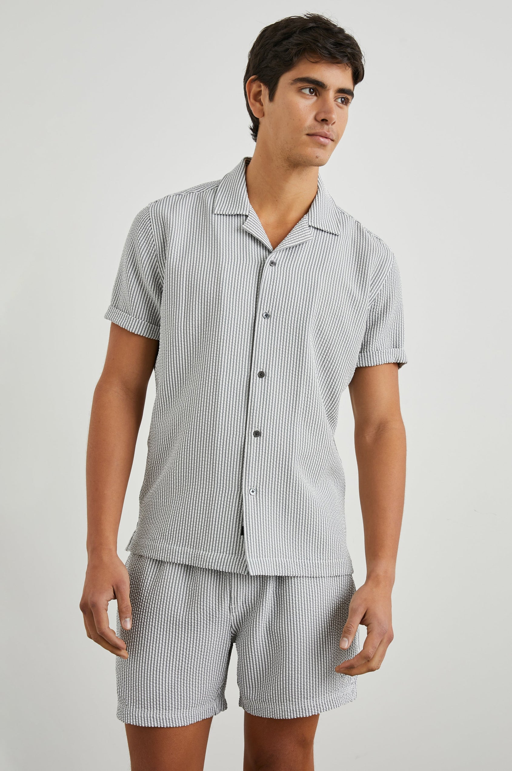 Amalfi Short-Sleeve Button Up in Faded Seersucker Colorway, Grey and white thin vertical stripes - Front View Featured on Model