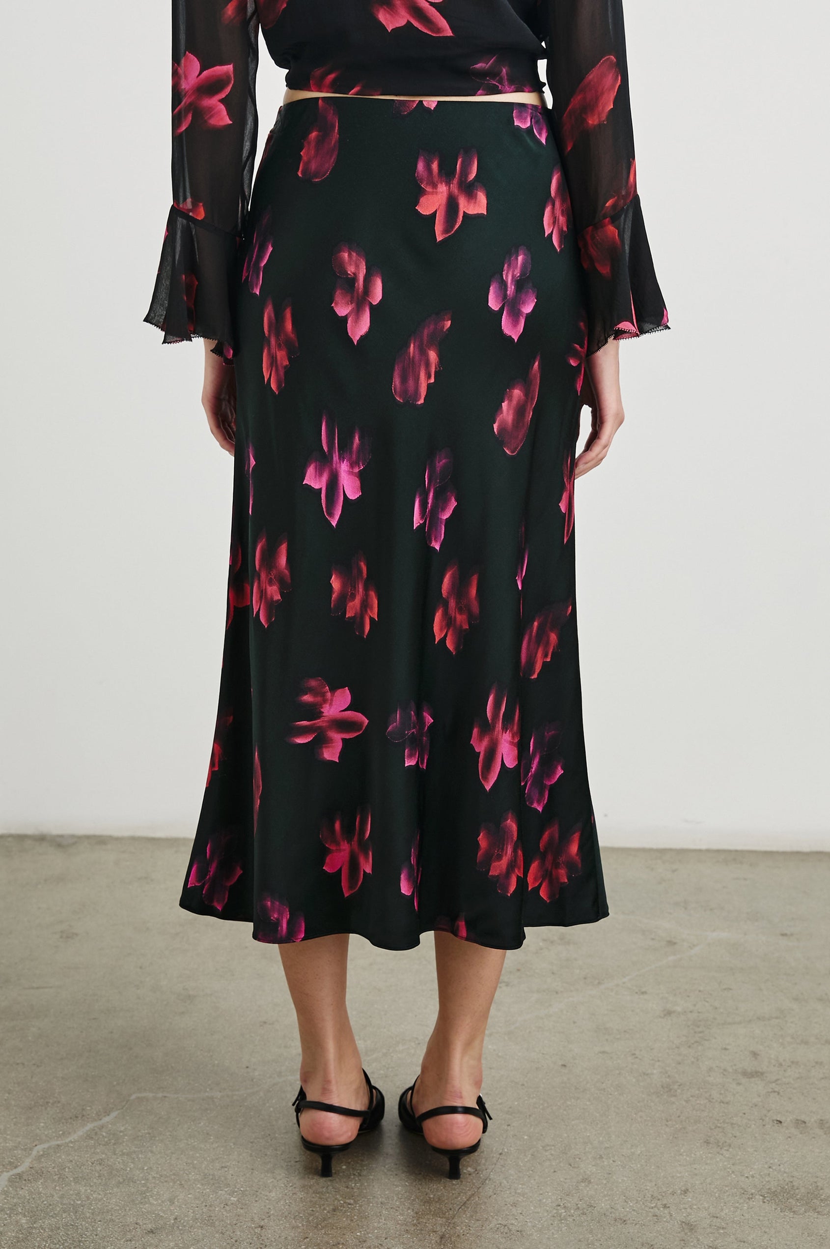 Anya High-waisted Midi Skirt in Dark Azalea Colorway, Flowers in pinks and purples on black - Back View Featured on model