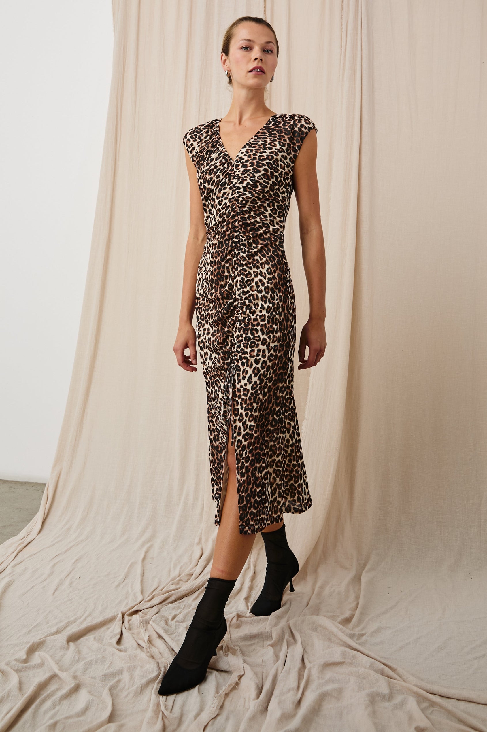 Auren Midi Dress with Cap Sleeves, a Deep V Neck, a Mid-Thigh Side Slit and Ruching from the V Neck to the Slit with a Drawcord at the Slit in Nala Colorway, Black and Brown Spots on Tan - Front Full Body View Featured on Model