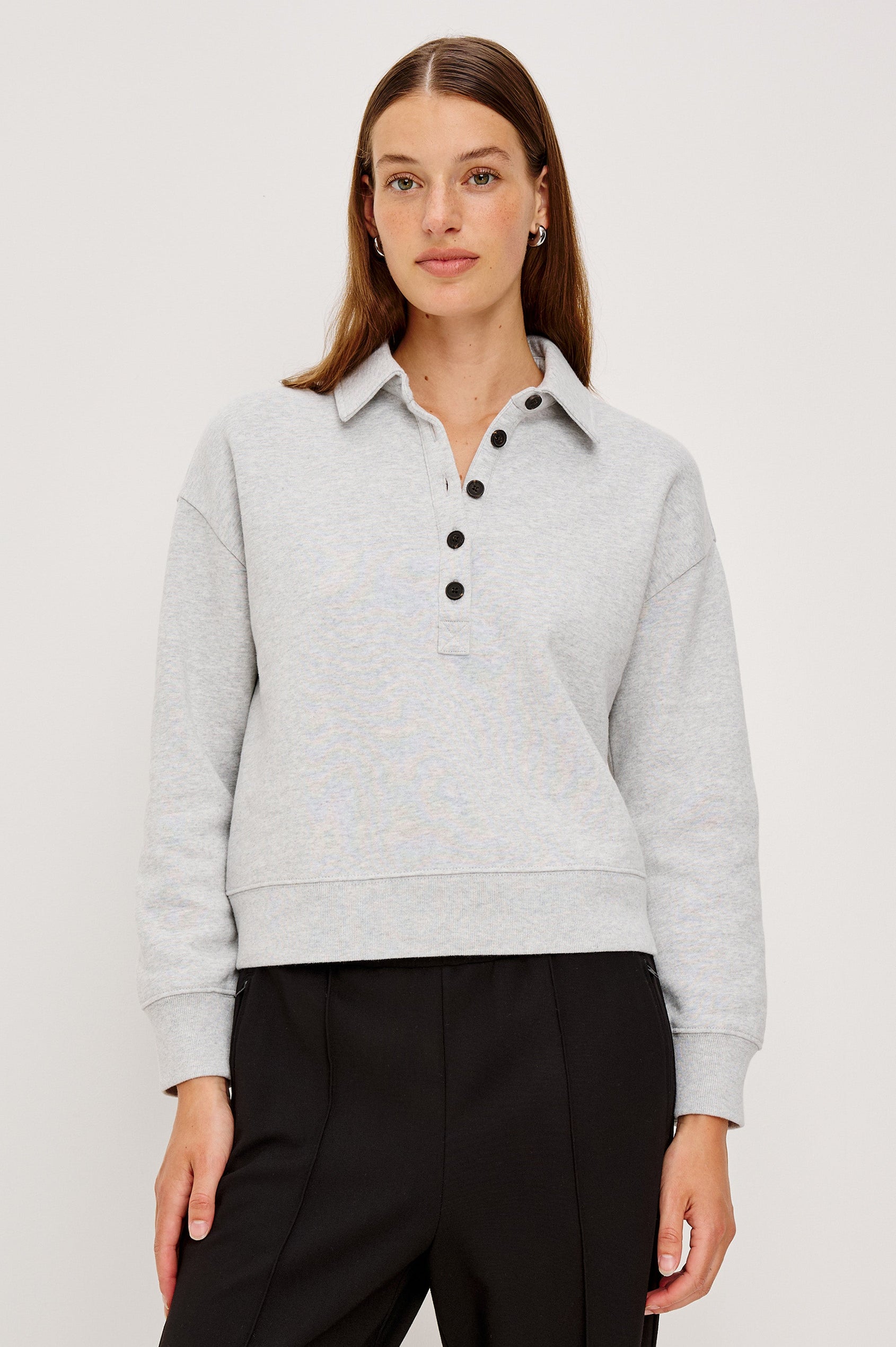 Cotton polo-style sweatshirt made from French terry fabric. The design features a button-front half placket, drop shoulders, and binding at the hem and cuffs for a relaxed, comfortable fit in Heather Grey Colorway - Front view featured on model