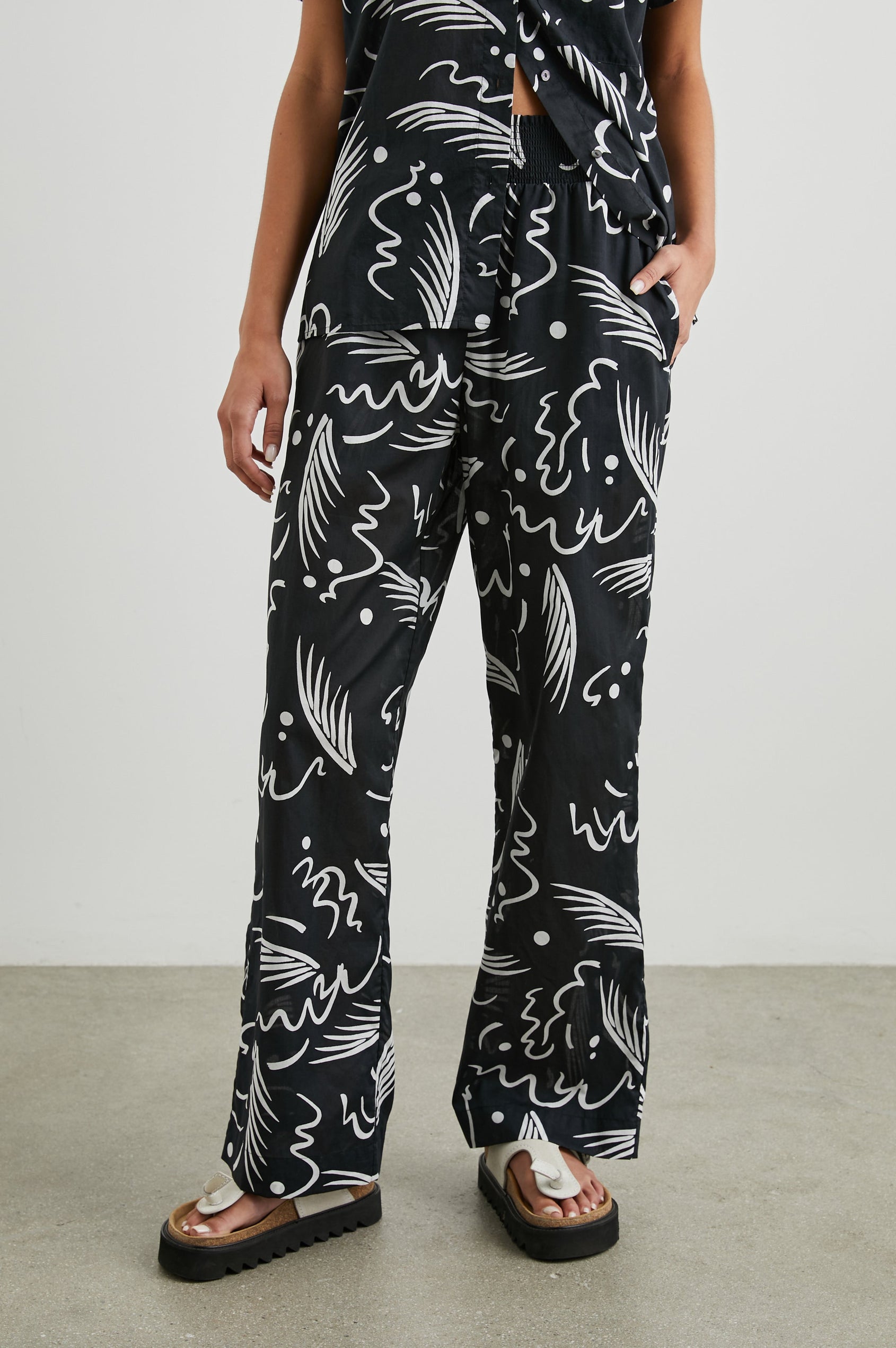 Brendon high-rise Pant with Elastic Waist and two front pockets in Tahiti Night Colorway, a white print on black - Front View Featured on Model