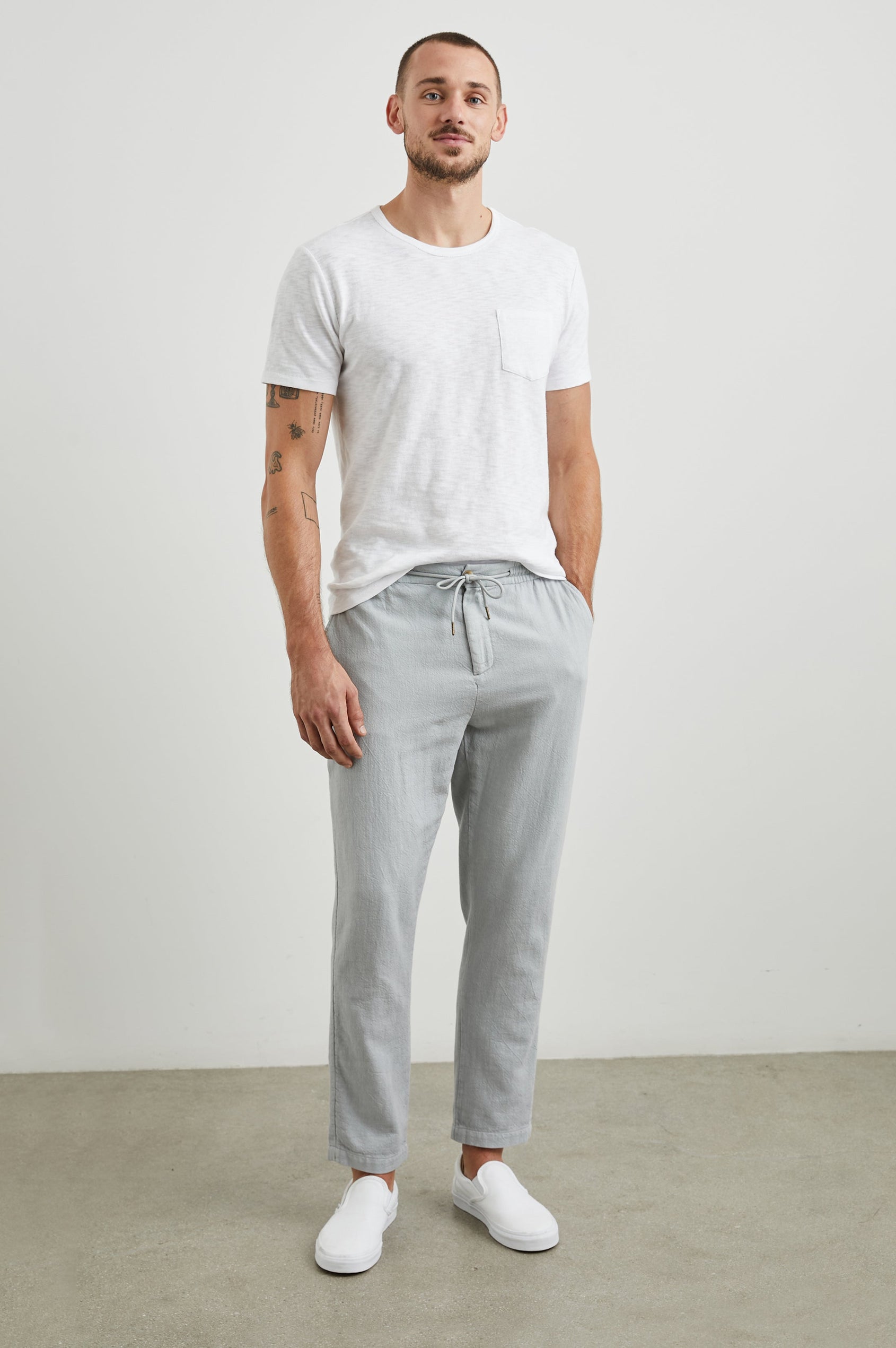 Callum Pants with a Drawstring Waist, Two Front Pockets and a Back Patch Pocket in Cement Colorway - Front Full Body View Featured on Model