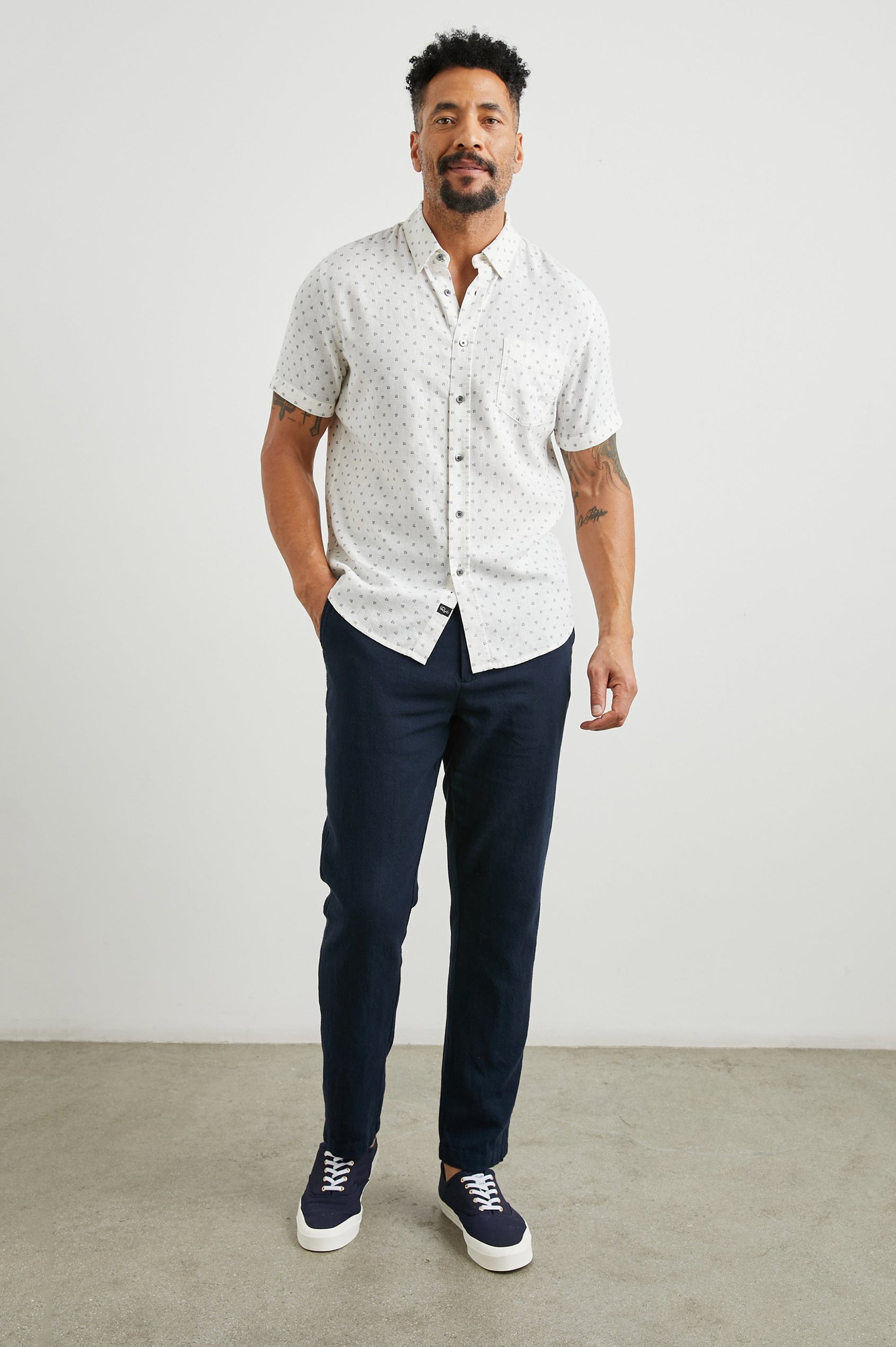 Carson Short Sleeve Button Up with a Chest Patch Pocket in Autumn Calico White Colorway, Small Blue Flowers on White- Front Full Body View Featured on Model