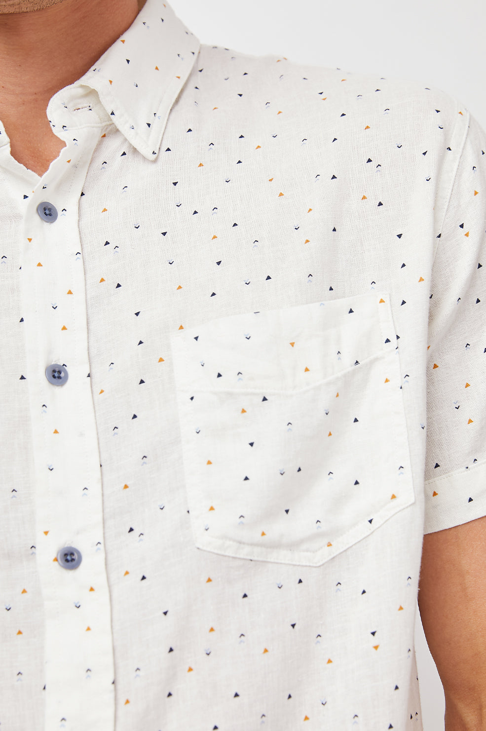 Carson Short Sleeve Button Up with a Chest Patch Pocket in Triangle Geo Colorway, Small Tan, Grey and Black Triangles on White - Front View Featured on Model