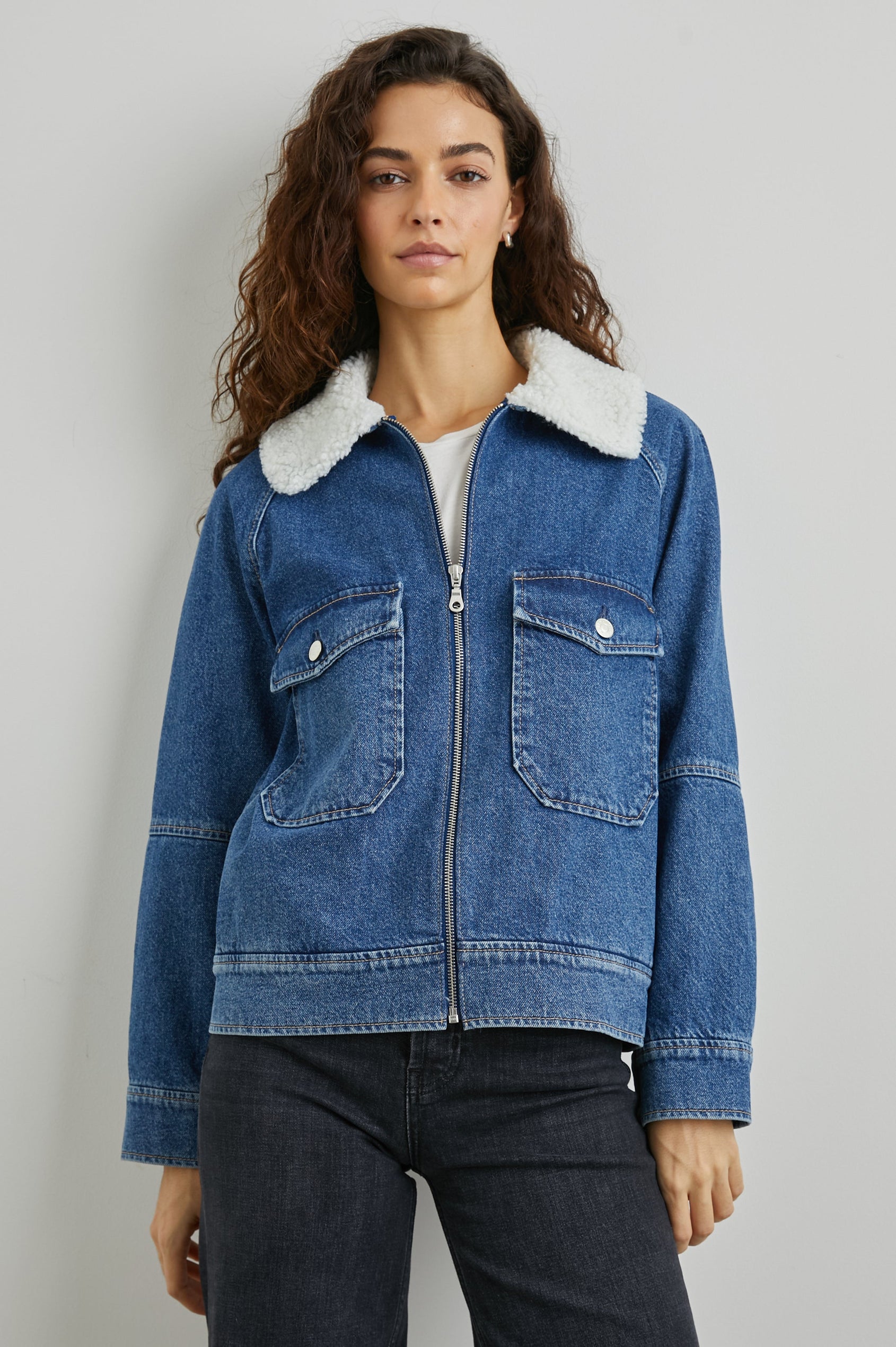 Cheyenne Zip-Up Denim Jacket with Two Buttoned Chest Flap Pockets, and Faux Shearling Collar in Indigo Sherpa Colorway - Front View Featured on Model