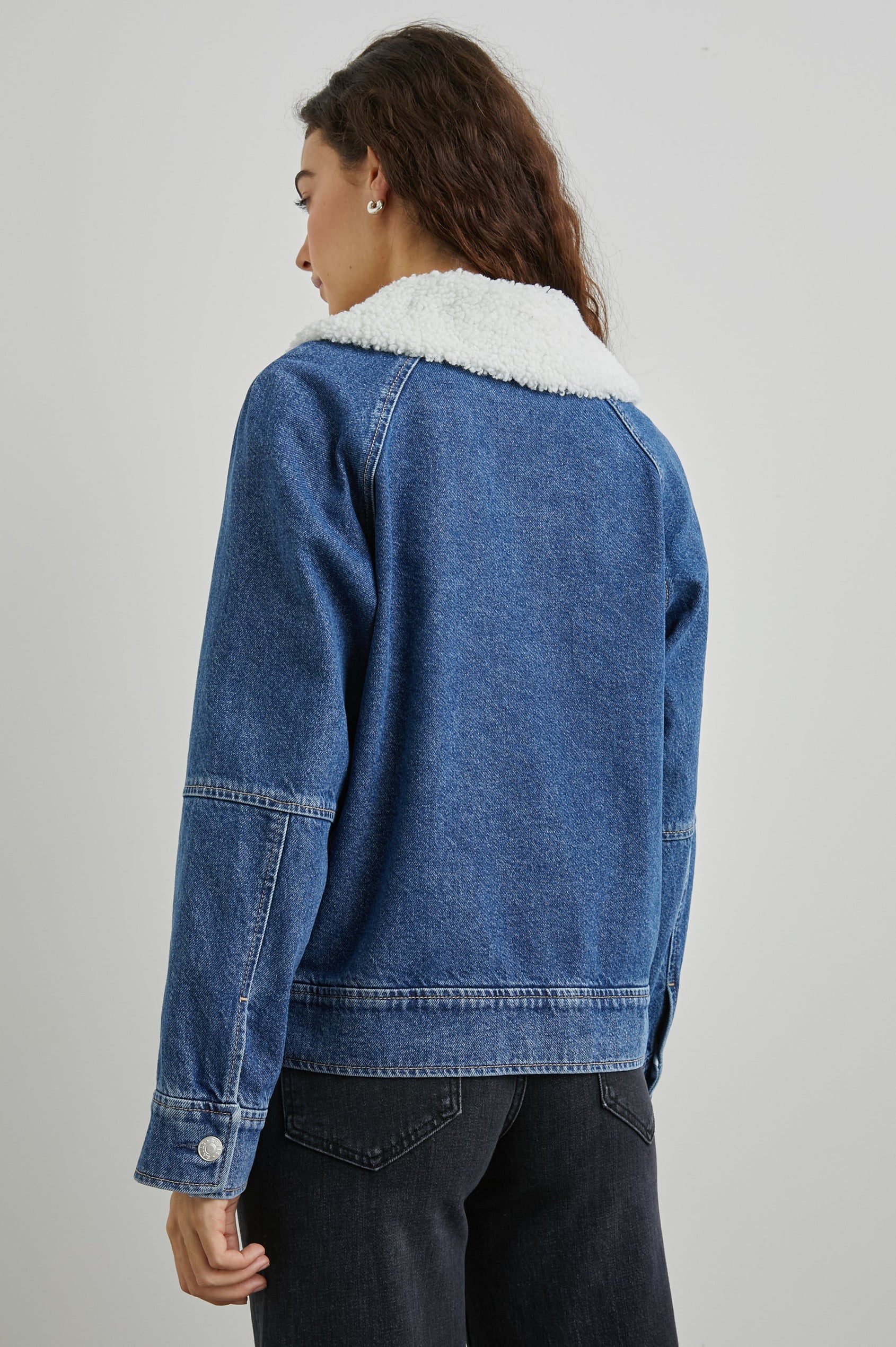 Cheyenne Zip-Up Denim Jacket with Two Buttoned Chest Flap Pockets, and Faux Shearling Collar in Indigo Sherpa Colorway - Back View Featured on Model