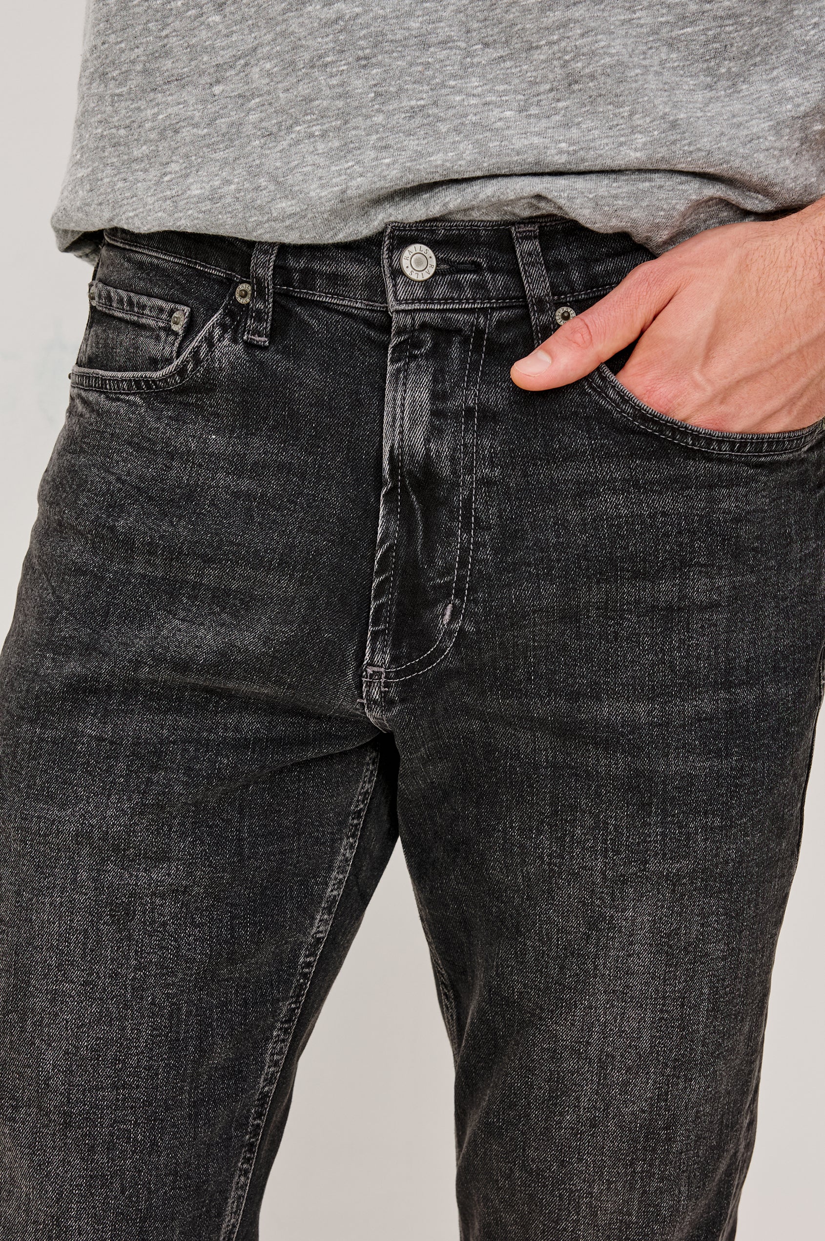 Clayton Slim Straight is a Classic 5-Pocket Jean in Faded Onyx Colorway, a Washed Black. Front Detail View Featured on Model.
