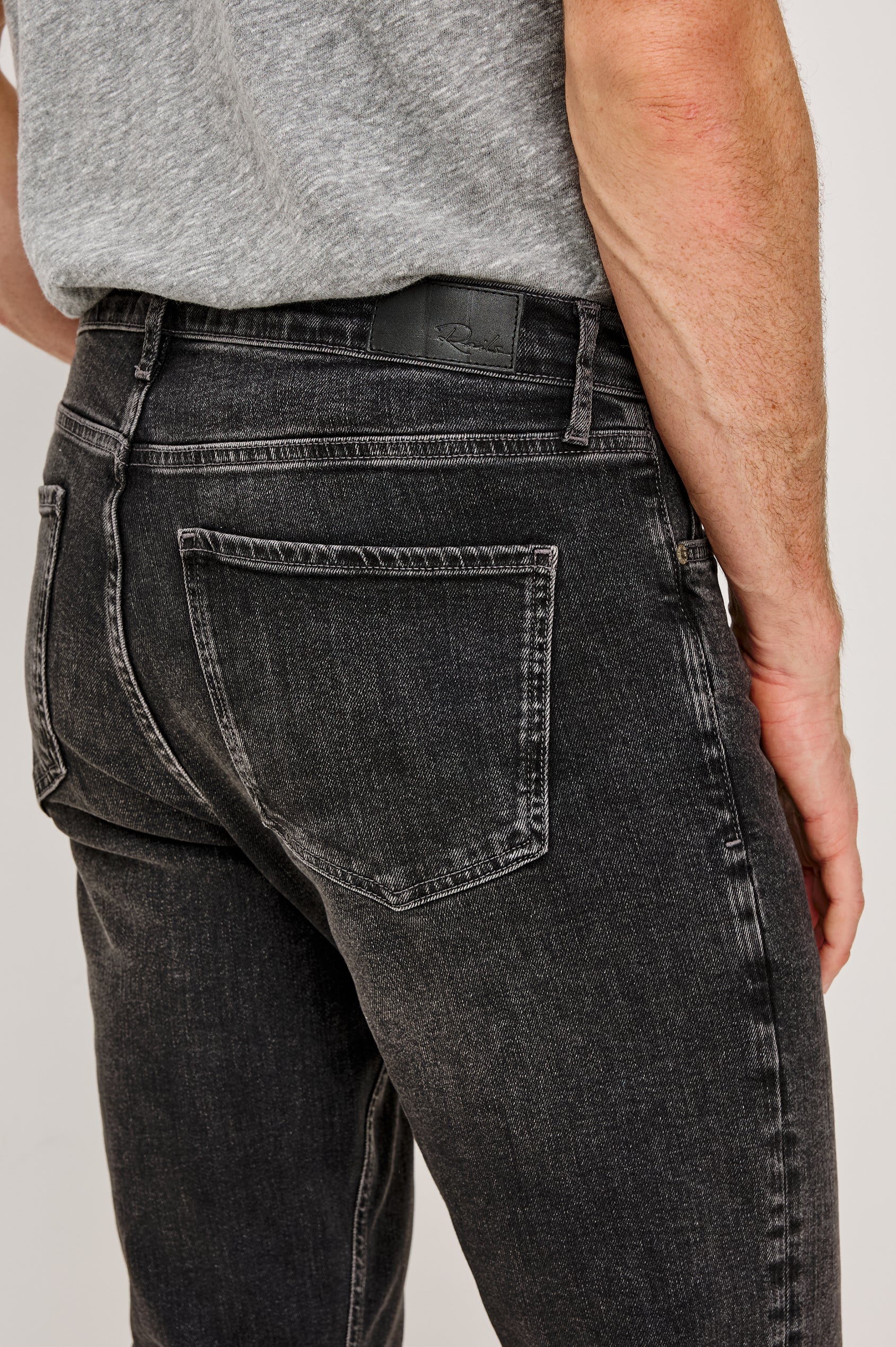 Clayton Slim Straight is a Classic 5-Pocket Jean in Faded Onyx Colorway, a Washed Black. Back Detail View Featured on Model.