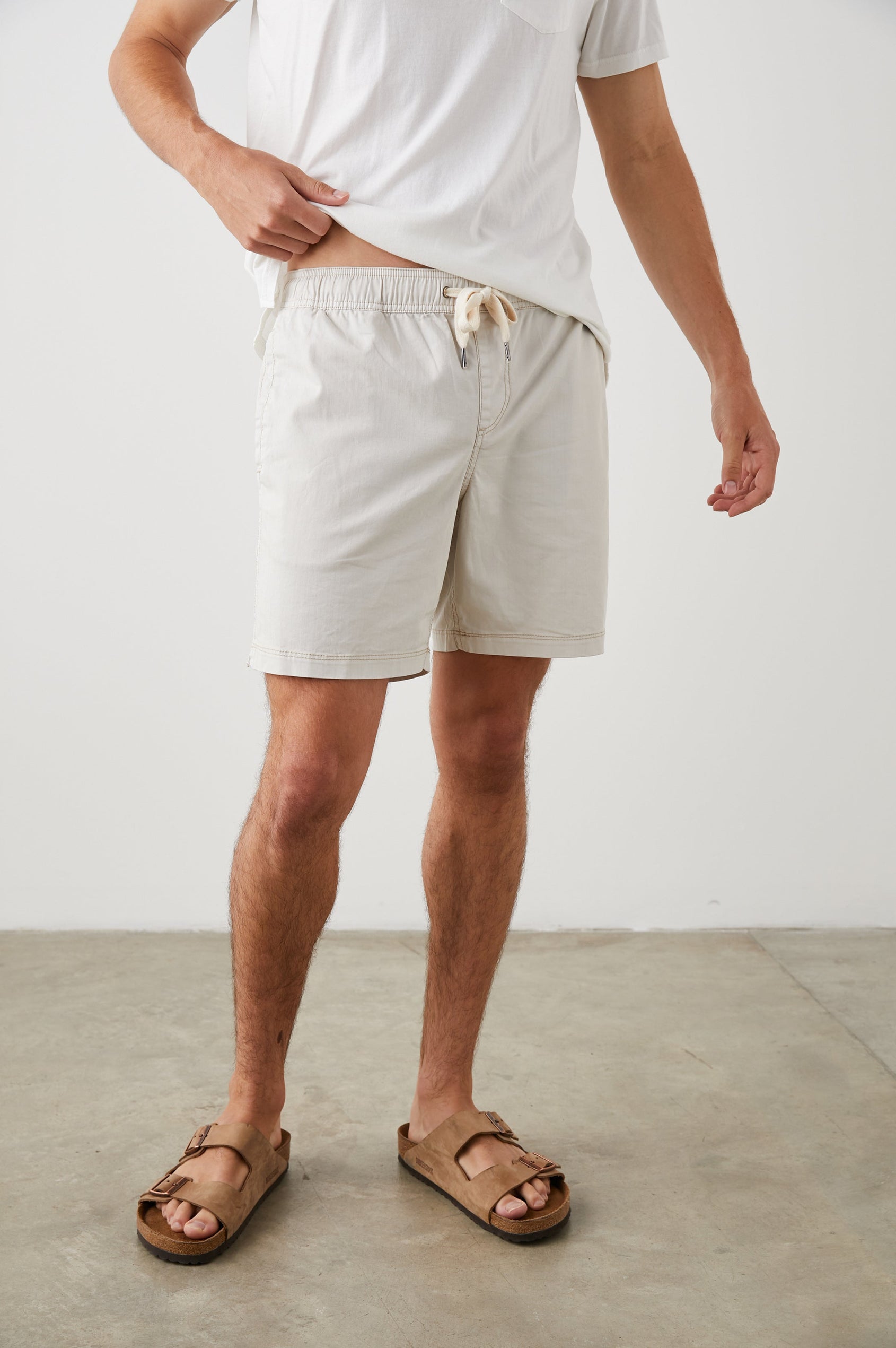 Cruz Shorts with a Drawstring Waist, Two Front Pockets, Two Back Button Flap Pockets in Natural Colorway - Front View Featured on Model