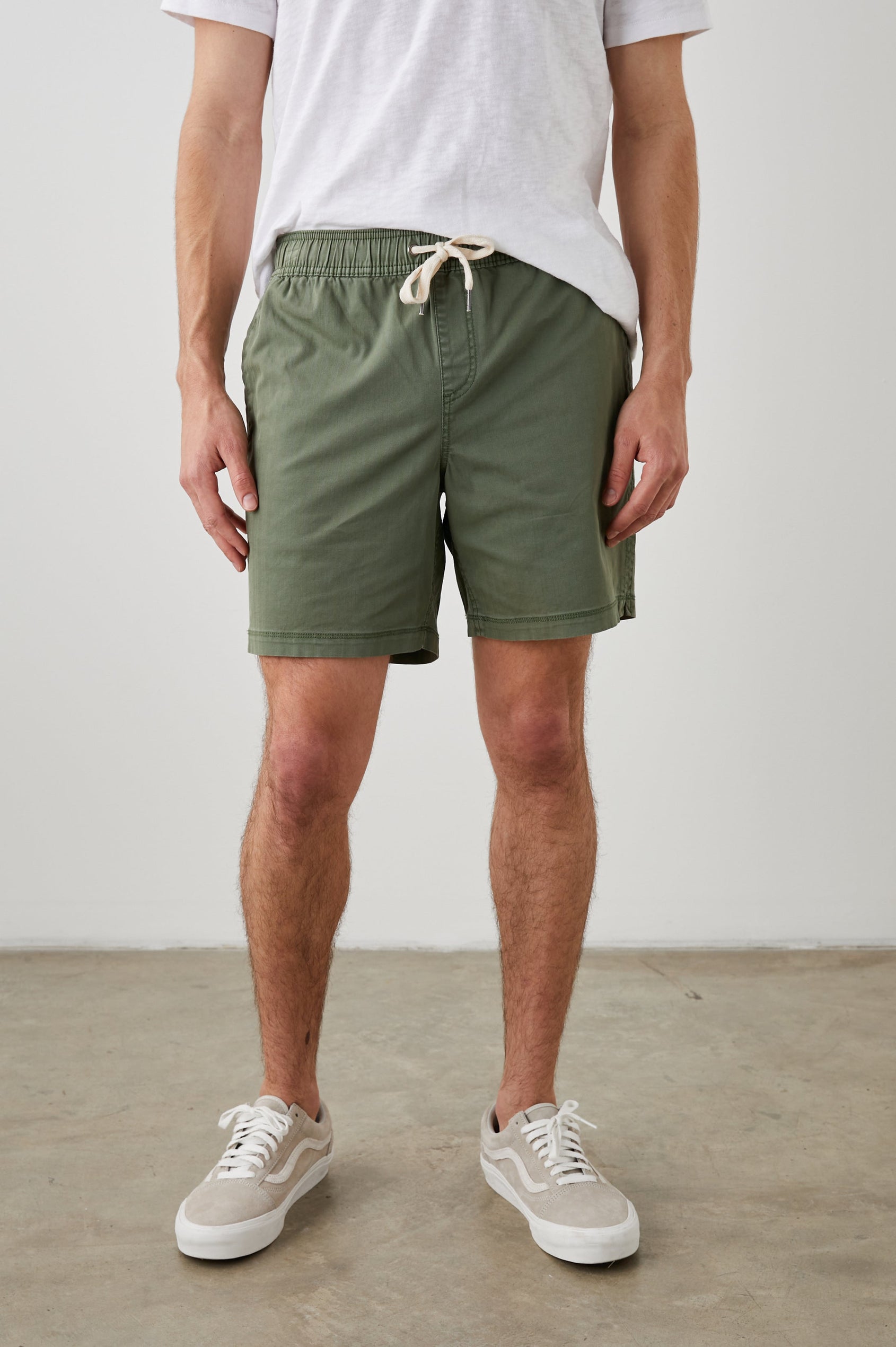 Cruz Shorts with a Drawstring Waist, Two Front Pockets, Two Back Button Flap Pockets in Spring Olive Colorway - Front View Featured on Model