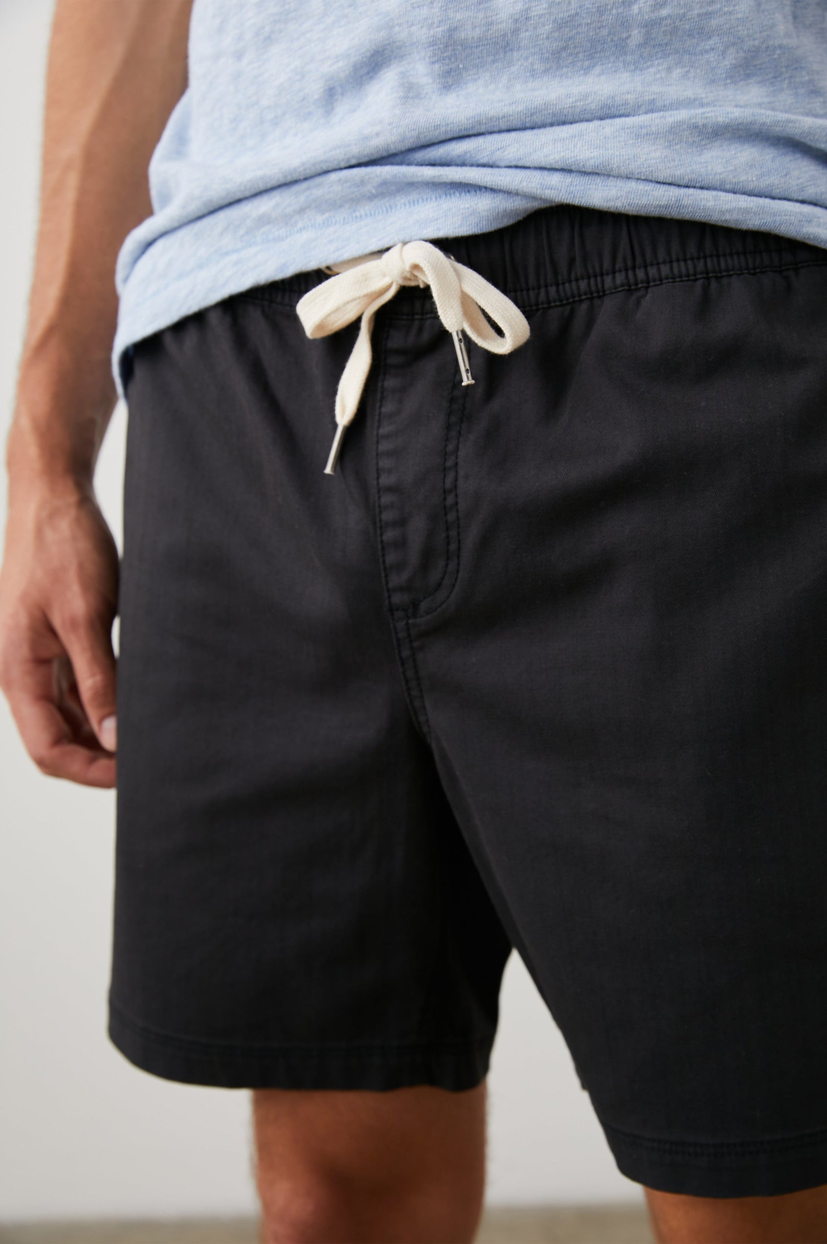 Cruz Shorts with a Drawstring Waist, Two Front Pockets, Two Back Button Flap Pockets in Washed Black Colorway - Front View Featured on Model