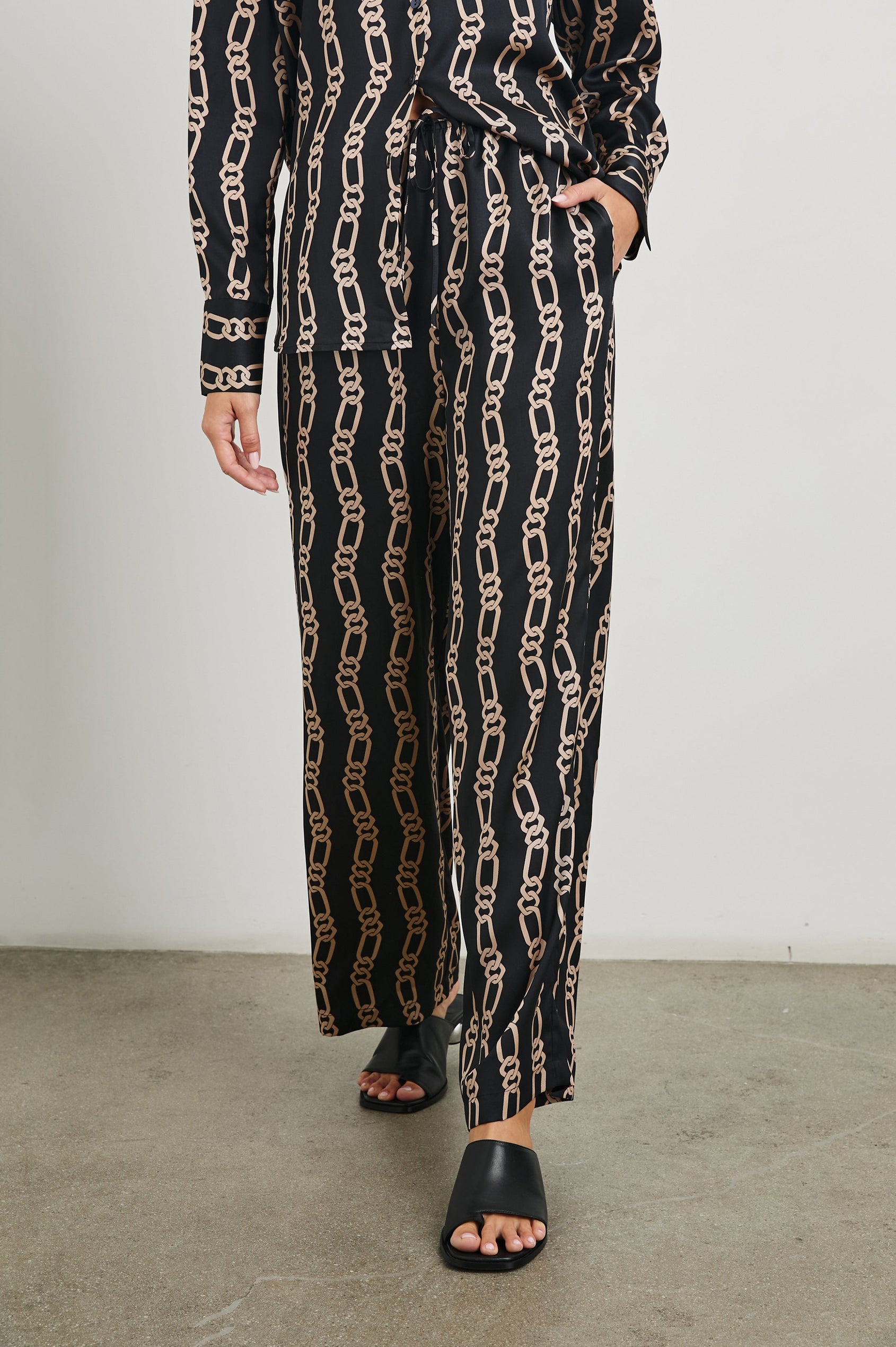 Damini Pants with a Drawstring Waist and Two Front Pockets in Black Gold Link Colorway, with Vertical rows of gold links on black - Front View Featured on Model