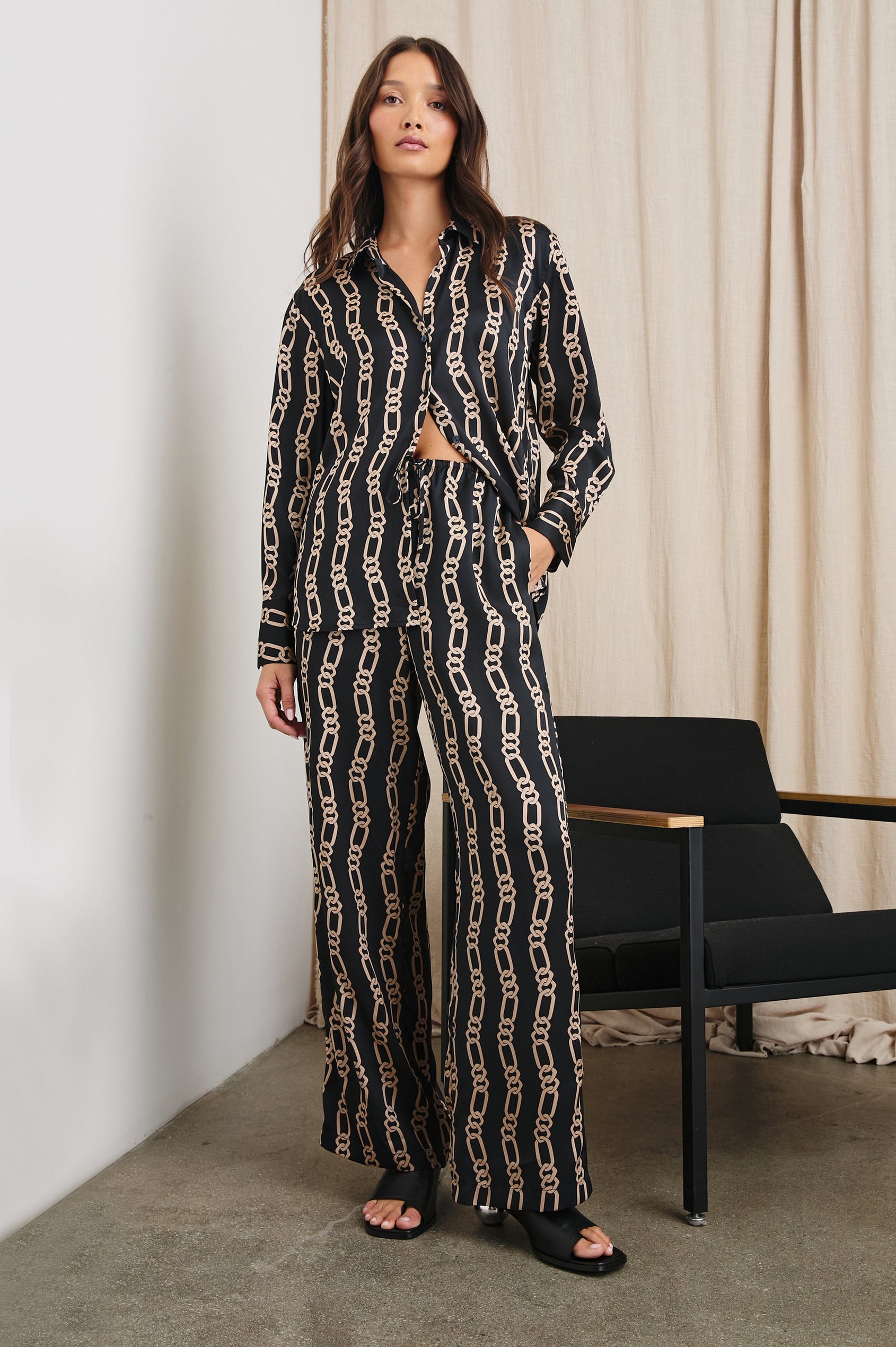 Damini Pants with a Drawstring Waist and Two Front Pockets in Black Gold Link Colorway, with Vertical rows of gold links on black - Front Full Body View Featured on Model