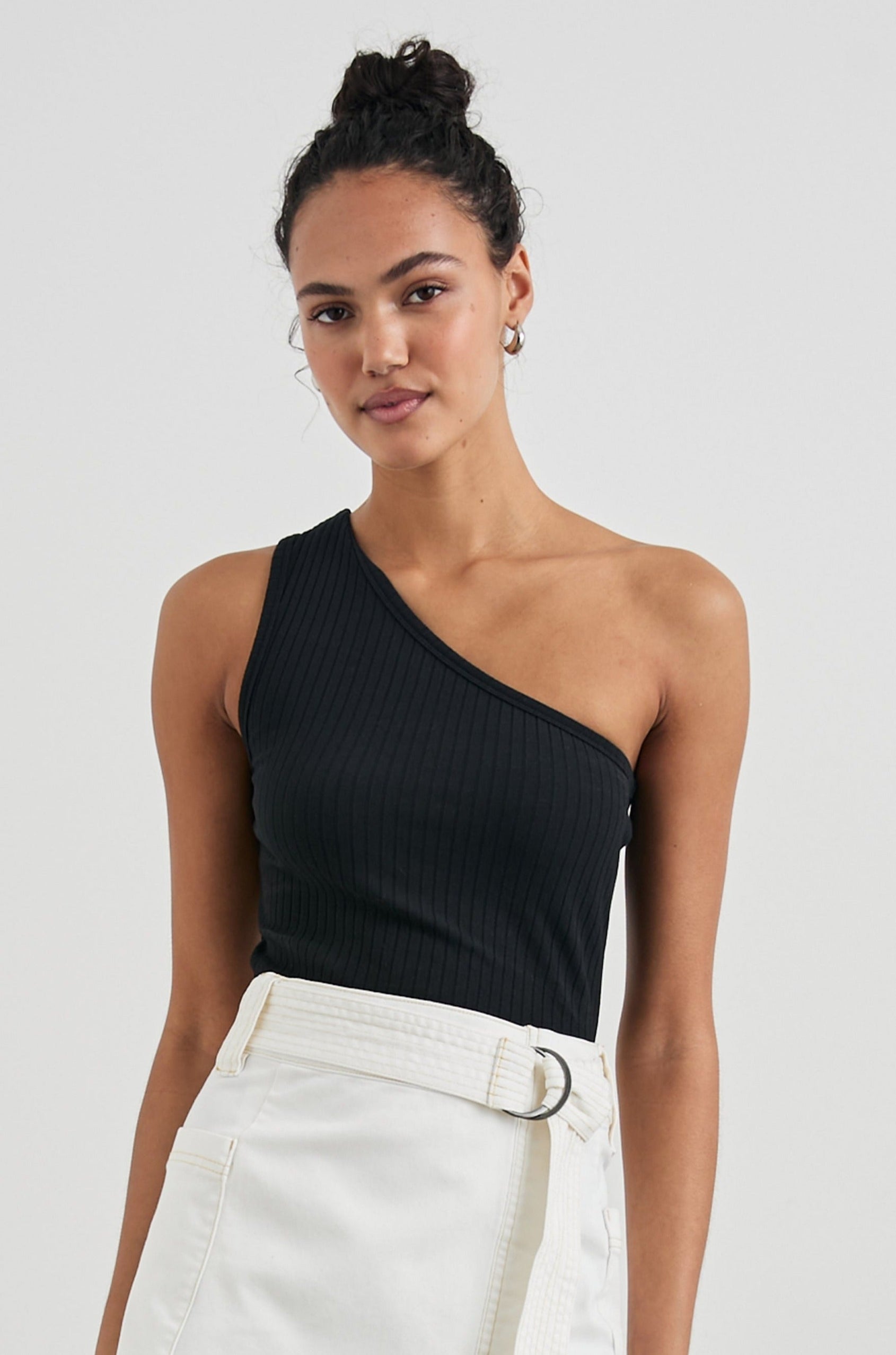 Esti Sleeveless Ribbed Top with an Asymmetrical Neckline with One Strap in Black Colorway - Front Tucked View Featured on Model