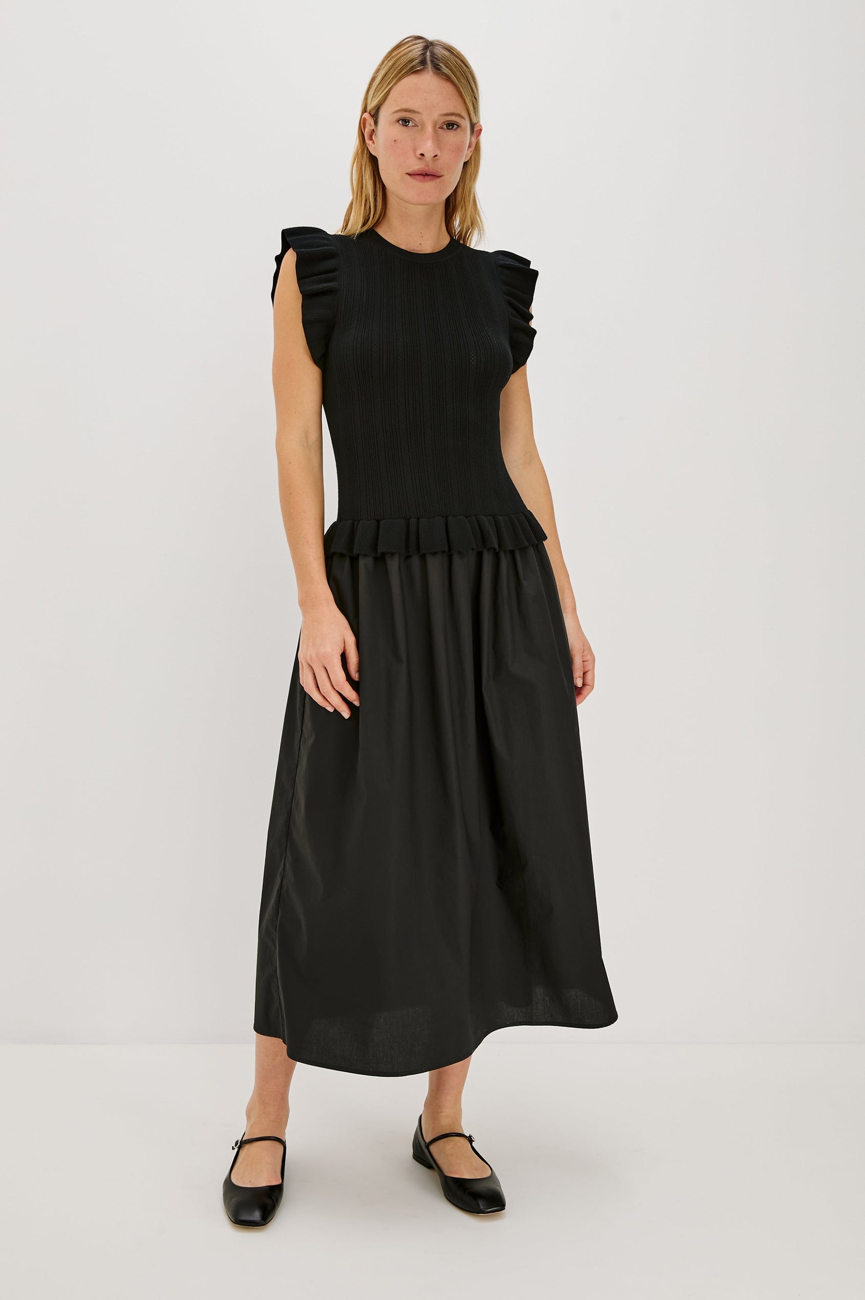 Deirdre, a maxi dress with a fitted fine-gauge knit bodice and flutter sleeves. The dress transitions at the waist into a full cotton poplin skirt, creating a soft, mixed-fabric silhouette. Full Body Front View featured on Model.
