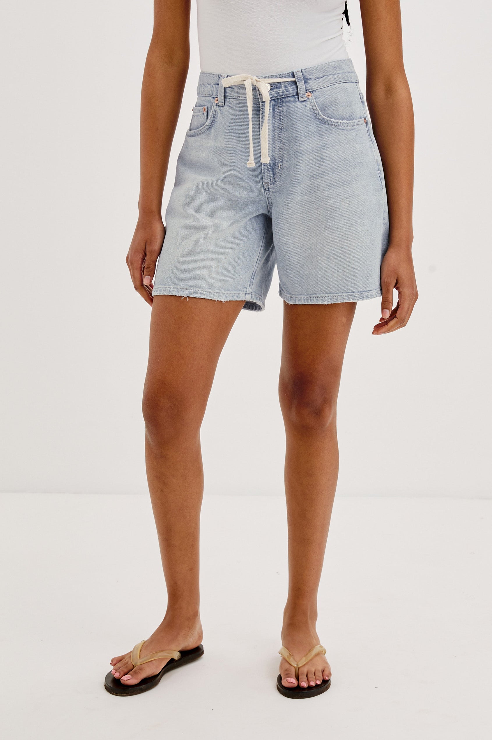 Dume Denim Short, Five Pocket, Zip Fly, Mid-Thigh Length with a White Drawstring Tie Waist in Light Wash Scuba Colorway. Front View Shown on Model.