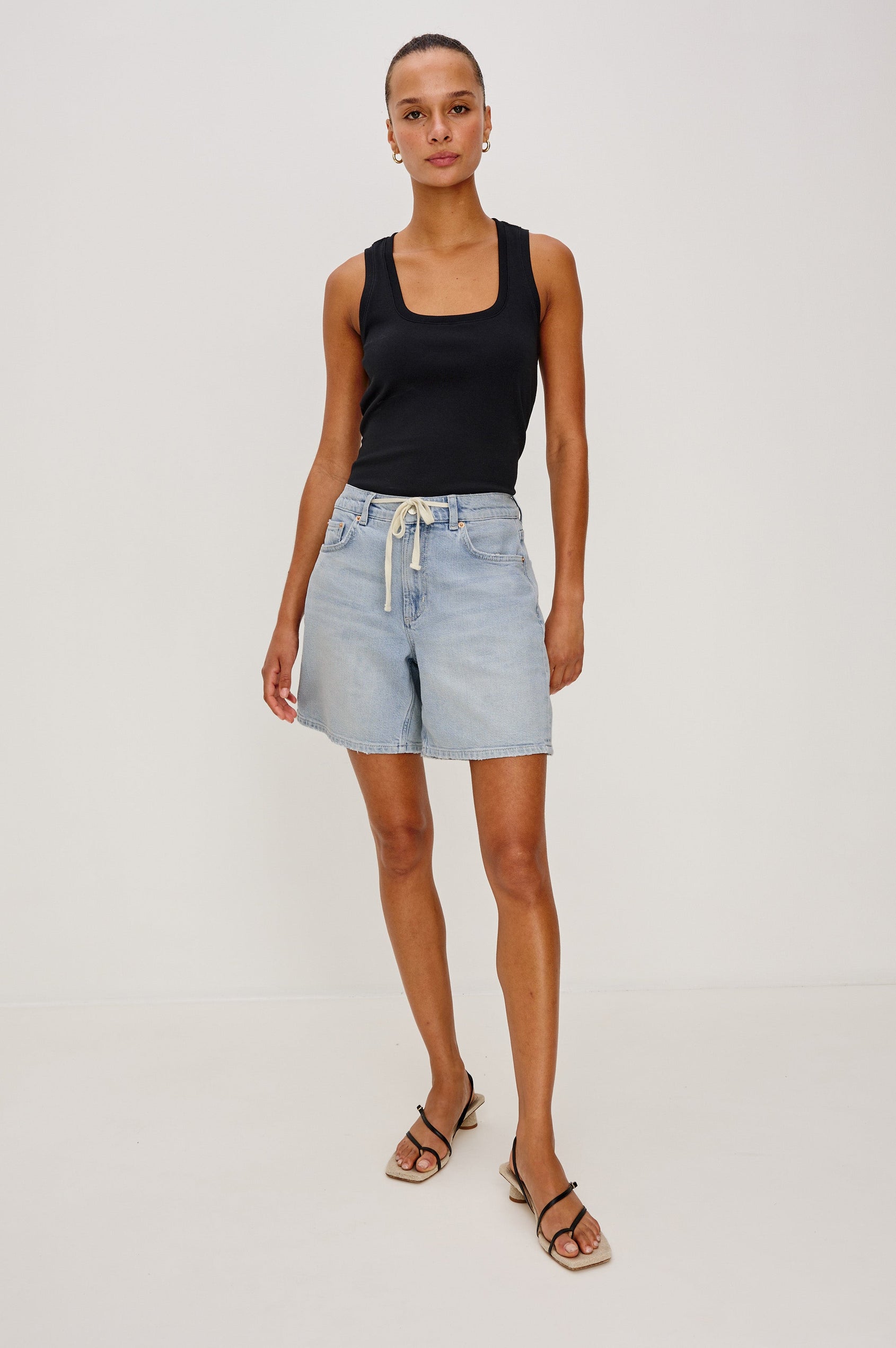 Dume Denim Short, Five Pocket, Zip Fly, Mid-Thigh Length with a White Drawstring Tie Waist in Light Wash Scuba Colorway. Front View Shown on Model.