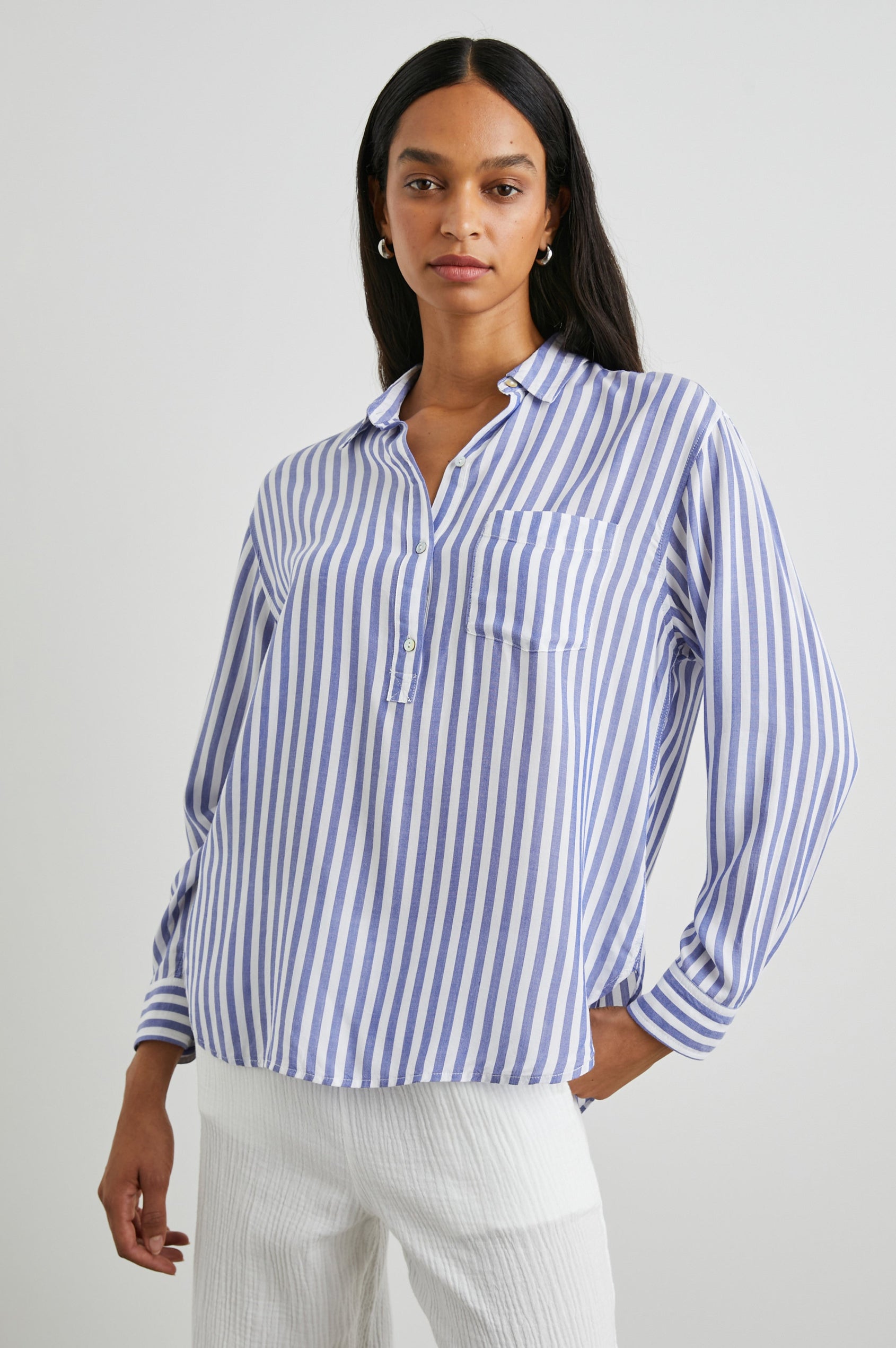 Elle Long Sleeve Shirt with a Four Button Placket, Buttoned Cuffs, a Chest Pocket and a Collar in Blue White Stripe Colorway, Vertical Stripes - Front View Featured on Model