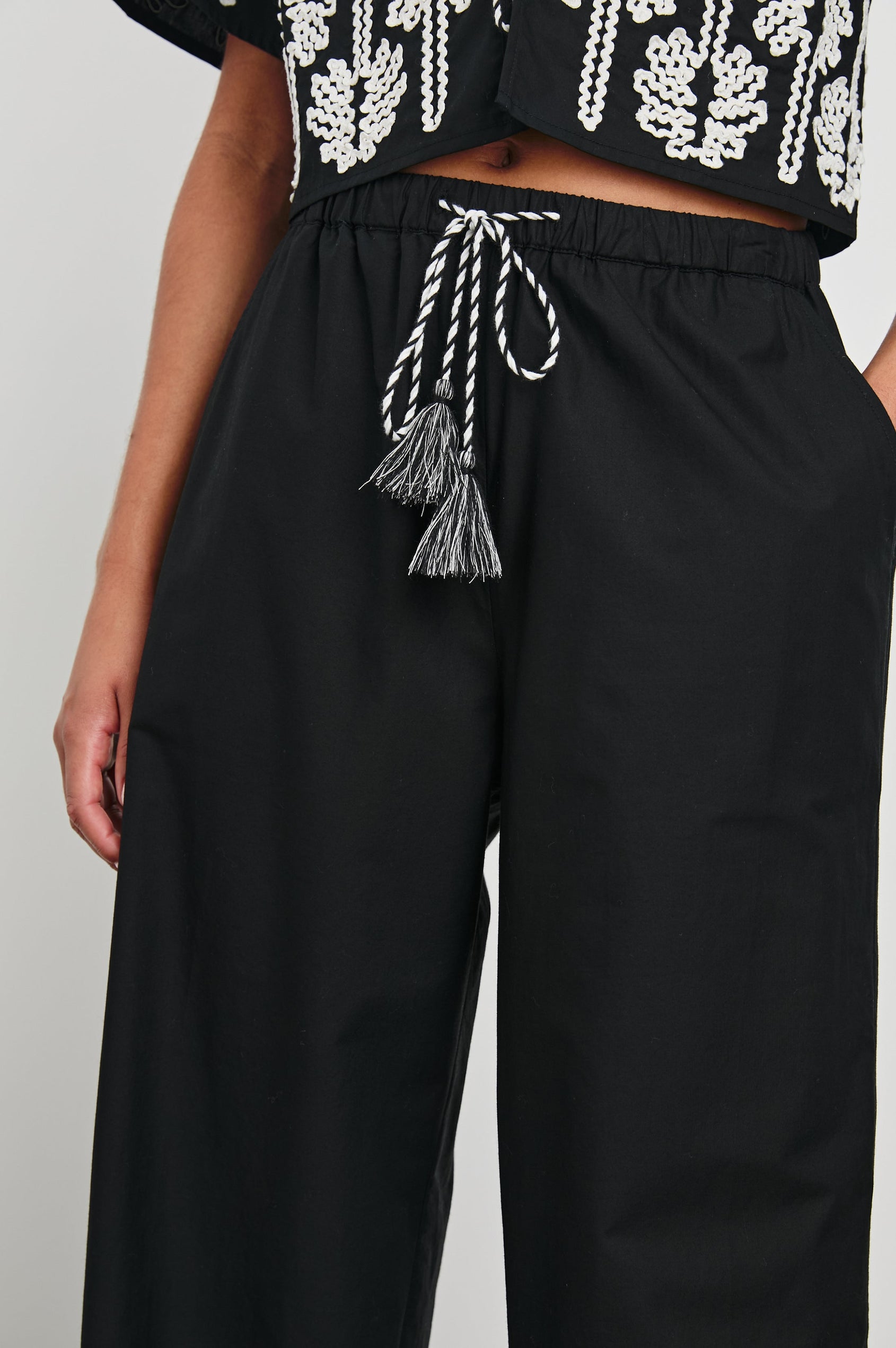 Emmie Pants with a Drawstring Waist and Two Front Pockets in Black Ivory Palm Trees Colorway, with white palm trees at the cuffs - Front View Featured on Model