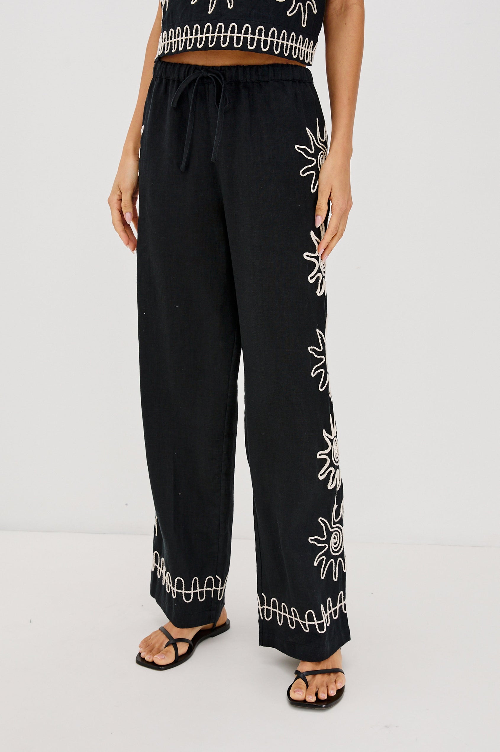 Emmie Straight Leg Pant with Adjustable Drawstring at Waist in White Contrast Sun Embroidery Colorway. Front View Shown on Model.