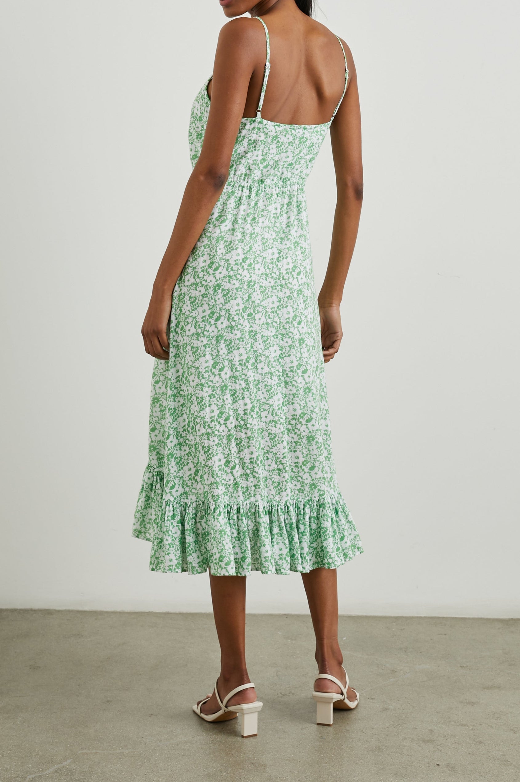Frida Midi Dress with a Deep V Neck, Adjustable Spaghetti Straps, a Ruffled Hem, Drawstring Waist Ties and Buttons Down the Front in Green Texture Floral Colorway, Green and White Flowers - Back Full Body View Featured on Model