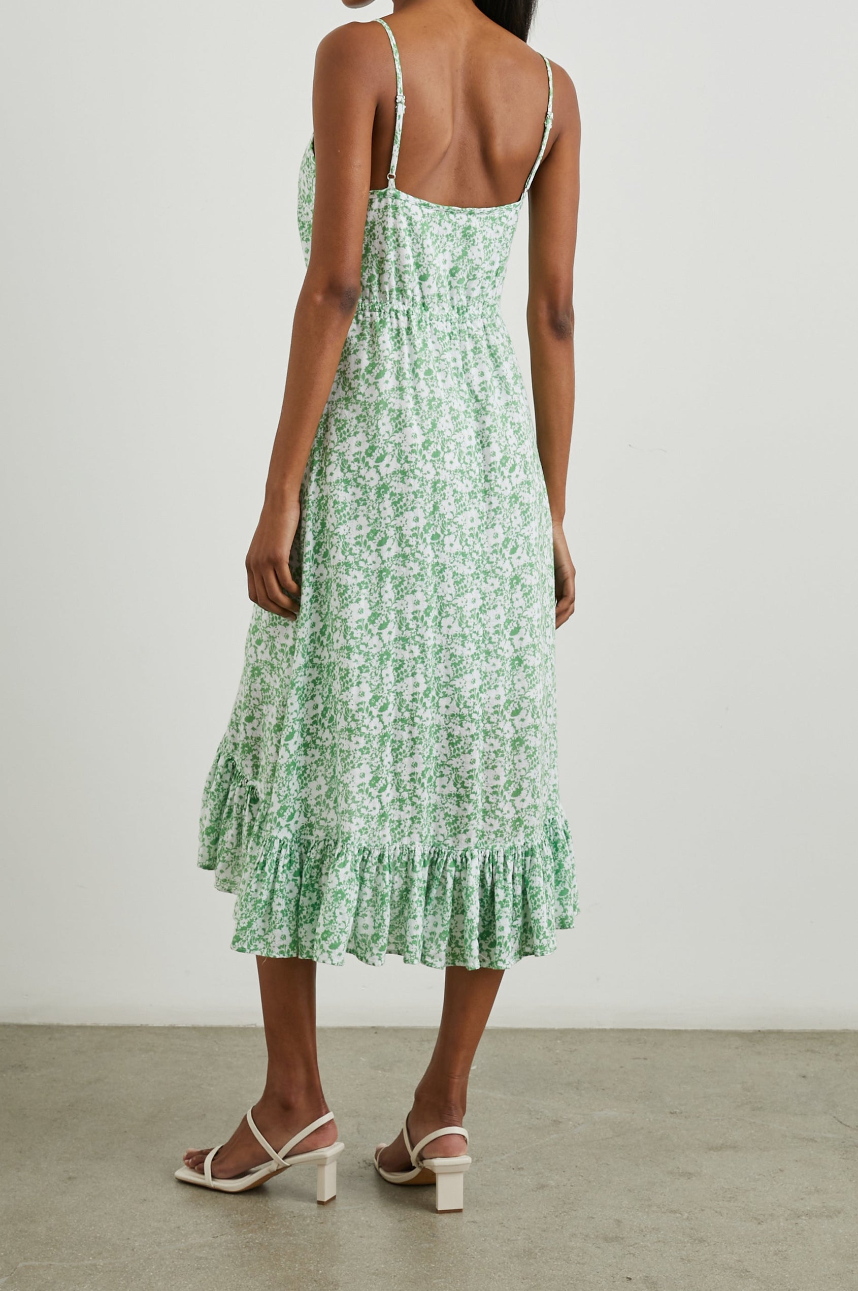 Frida Midi Dress with a Deep V Neck, Adjustable Spaghetti Straps, a Ruffled Hem, Drawstring Waist Ties and Buttons Down the Front in Green Texture Floral Colorway, Green and White Flowers - Back Full Body View Featured on Model