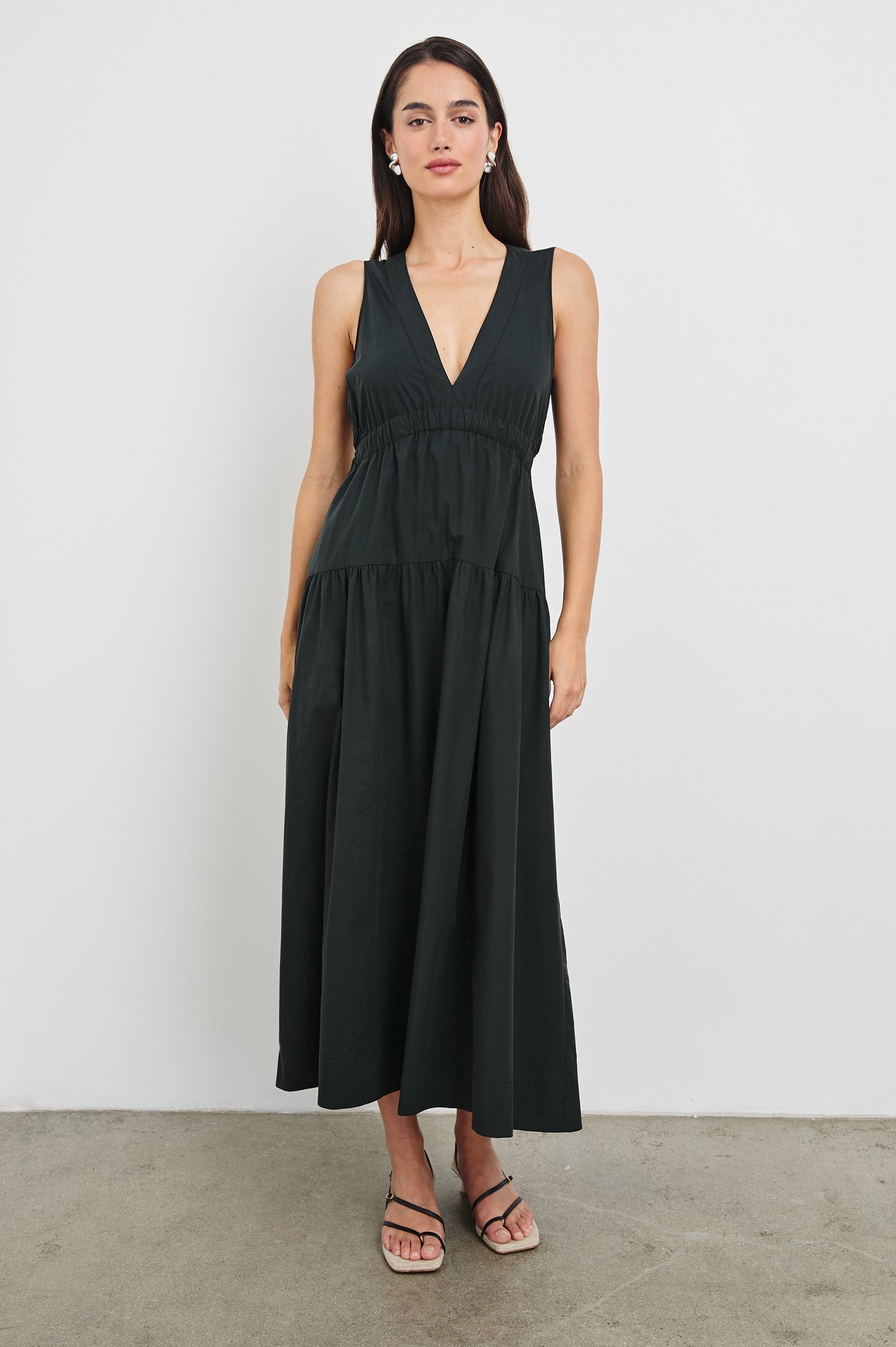 Genevieve Midi Tank Dress with Low V-Neck, Encased Elastic Waistband, Back Waist Cutout and Tiered A-Line Skirt in Black Colorway. Full Body Front View Shown on Model.