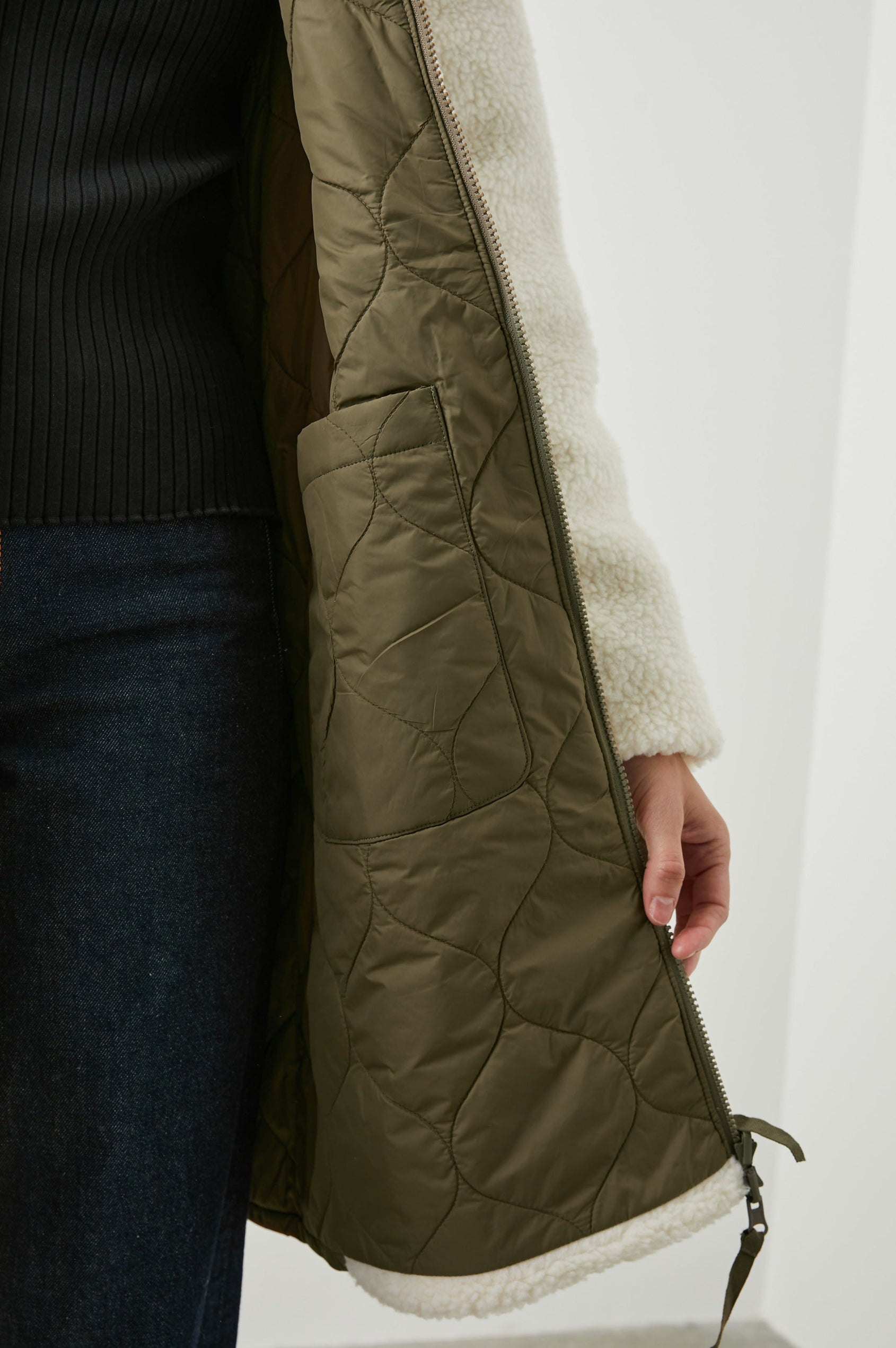 Granger Knee-Length Reversible Jacket with Zip Closure, One Side Quilted with Two Front Patch Pockets, the Reverse Side Ivory Sherpa Fleece with Olive Quilted Horizontal Bands in Ivory Olive Mix Colorway - Front View Featured on Model