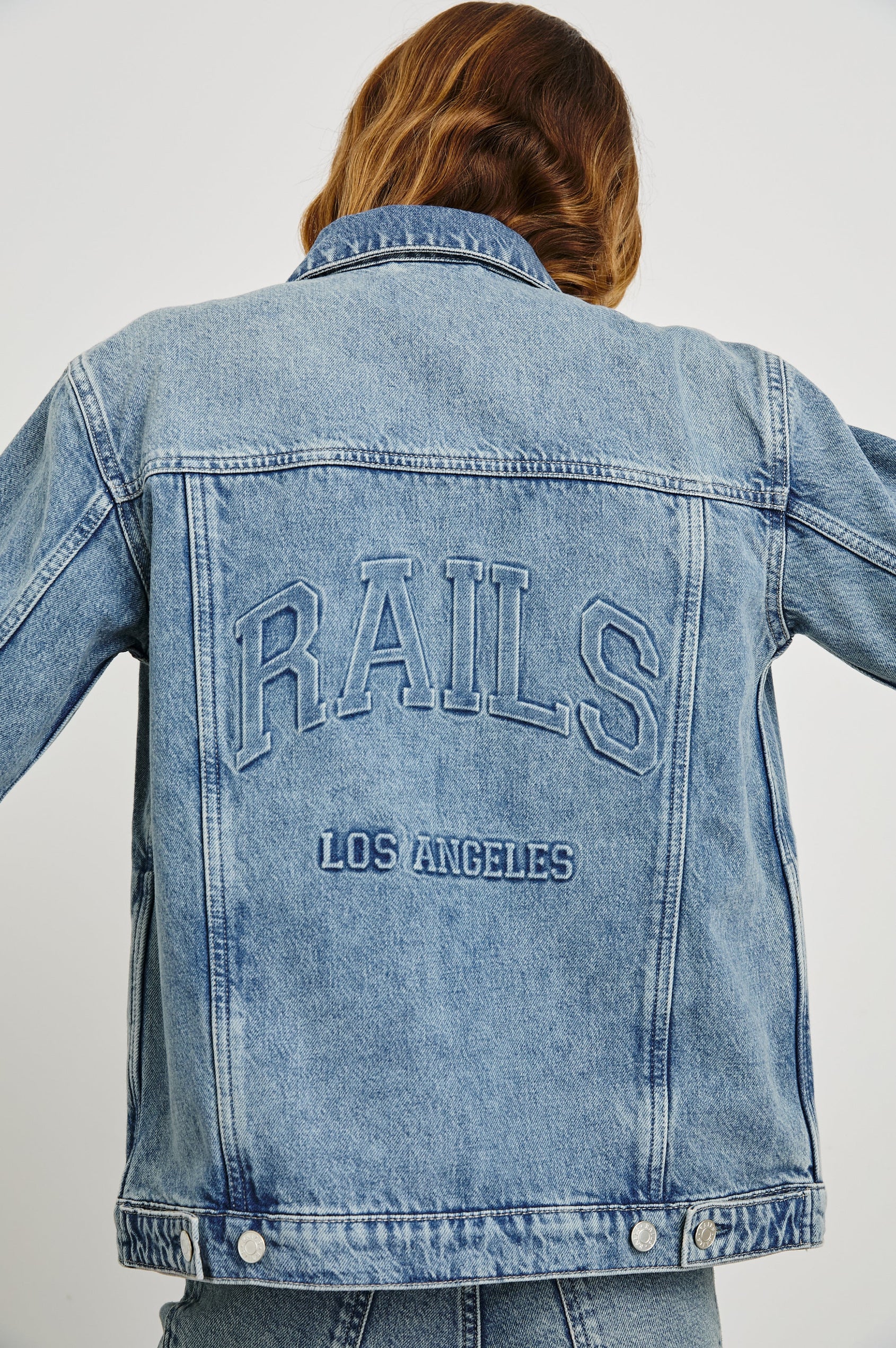 Grove Boyfriend Trucker Denim Jacket with Button Closure, Two Front Pockets, Two Chest Button Flap Pockets, Front Vertical Seams in Embossed Indigo Colorway - Back View Featured on Model