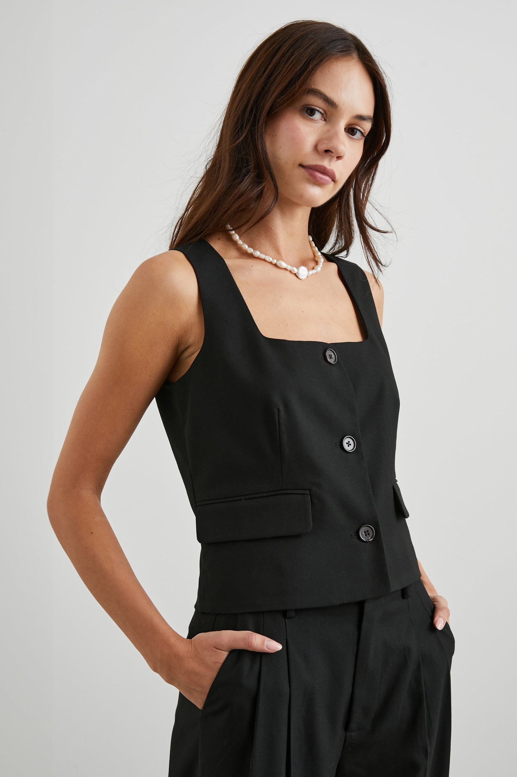 Guilia Cropped Vest with a Square Neckline, Button Closure and Two Front Flap Pockets in Black Twill Colorway - Front View Featured on Model