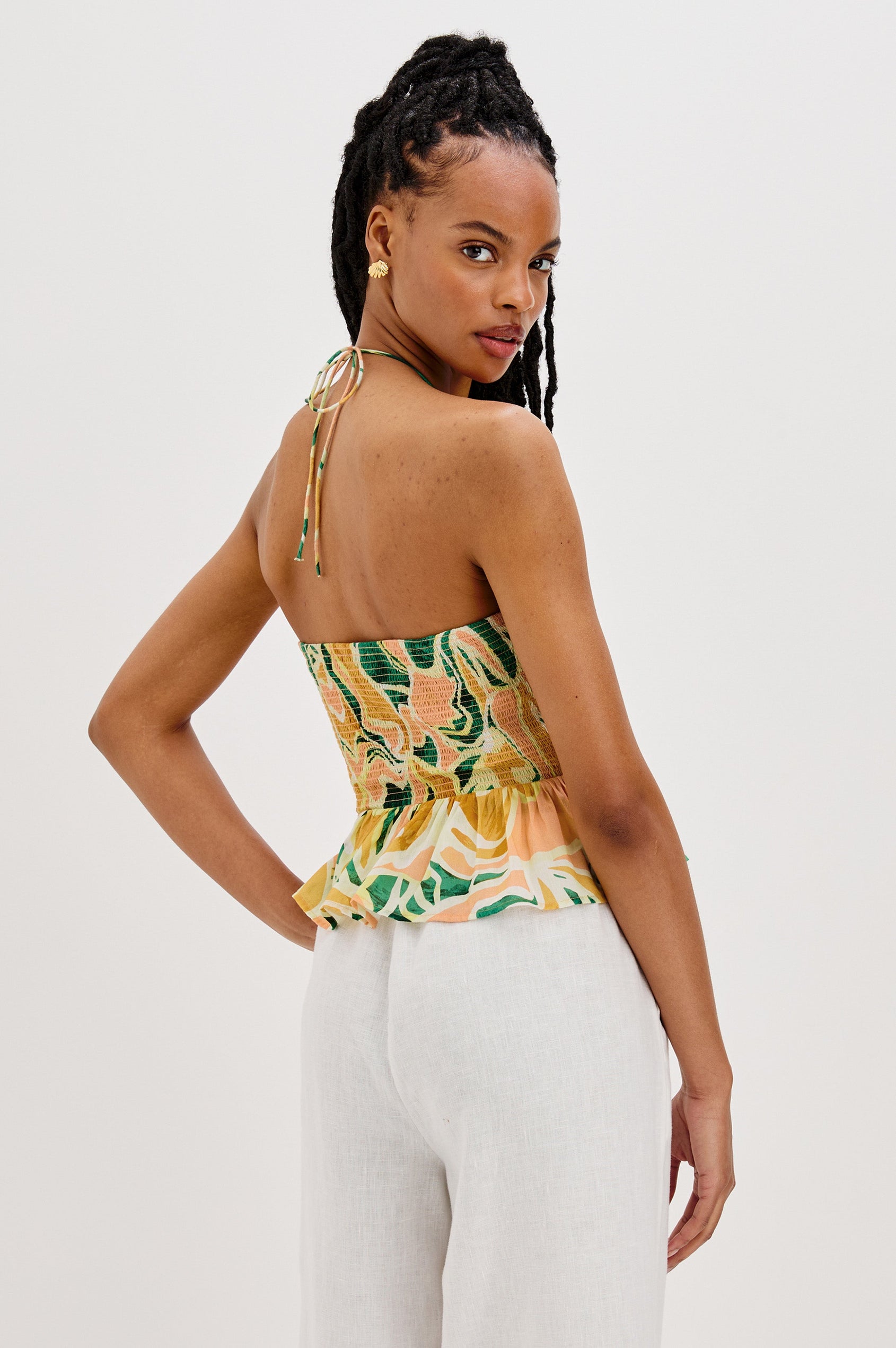 Gwendolyn Square Neck Halter Top with Smocked Body and a Ruffled Peplum Hem in Tulum Colorway. Back View Shown on Model.