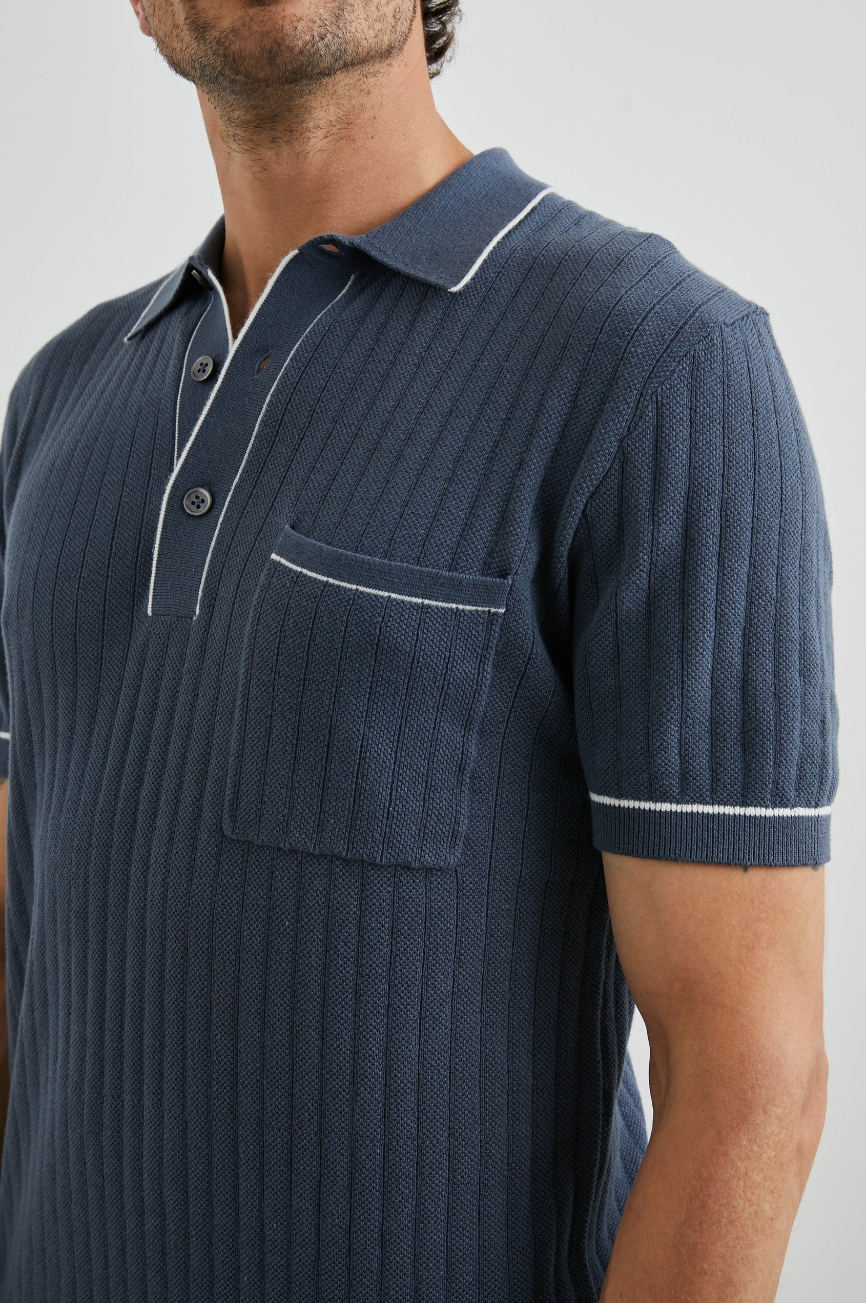 Hardy Short-Sleeve Ribbed Polo Shirt with a Chest Patch Pocket and a Three-Button Placket in Faded Navy Colorway, with White Trim - Front View Featured on Model