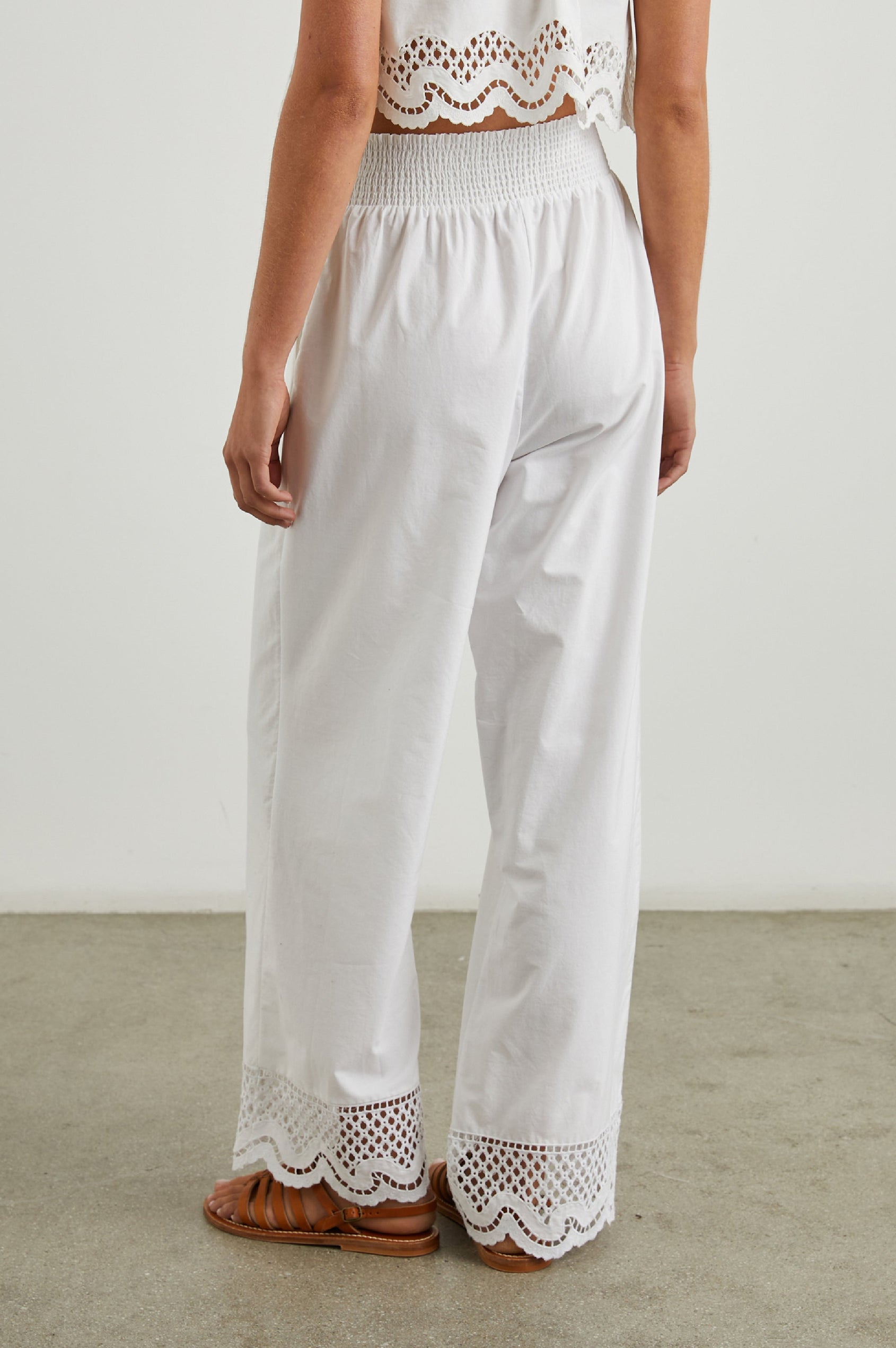 Henrik Pants with a Shirred Waist, Two Front Pockets and an Eyelet Design at the Hems in White Colorway - Back View Featured on Model