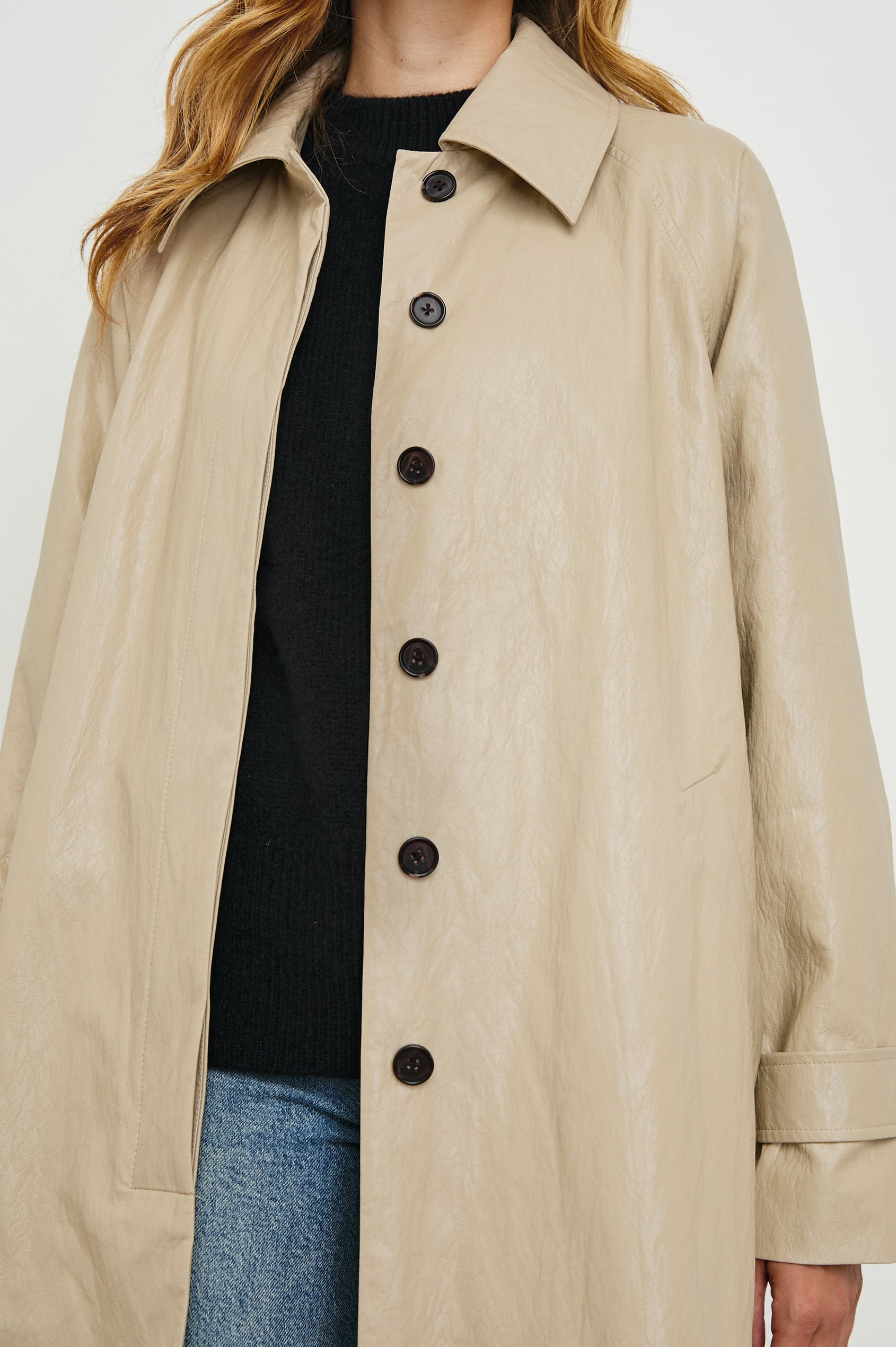 Hills Knee-Length Faux Leather Jacket with Button Closure, a Hidden Placket, Two Front Pockets, and Button Tabs at the Cuffs in Dune Colorway - Front View Featured on Model