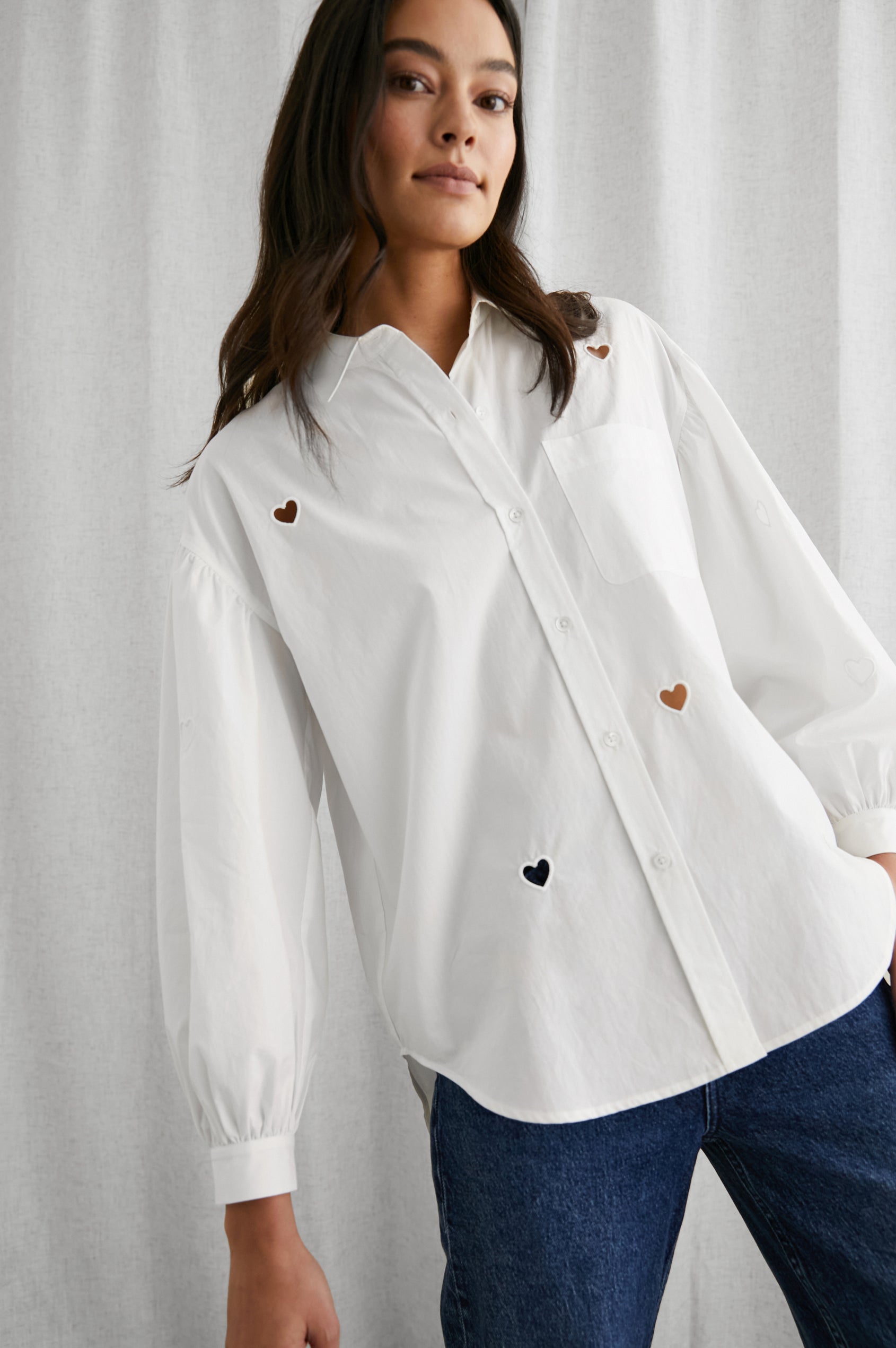 Janae Long Sleeve Button Up with a Chest Patch Pocket, Light Ruching at the Cuffs and Sleeve Shoulder and Cutout Hearts in White Eyelet Hearts Colorway - Front View Featured on Model