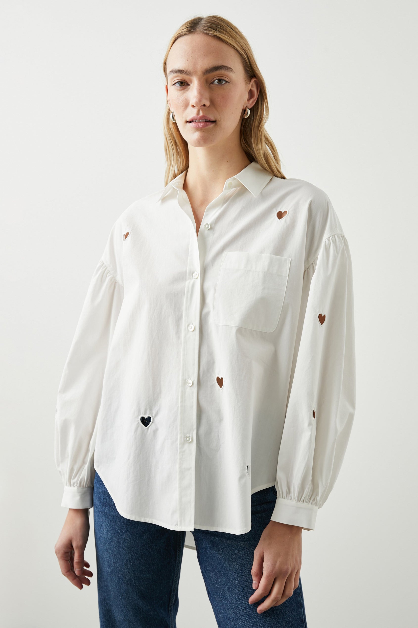 Janae Long Sleeve Button Up with a Chest Patch Pocket, Light Ruching at the Cuffs and Sleeve Shoulder and Cutout Hearts in White Eyelet Hearts Colorway - Front View Featured on Model