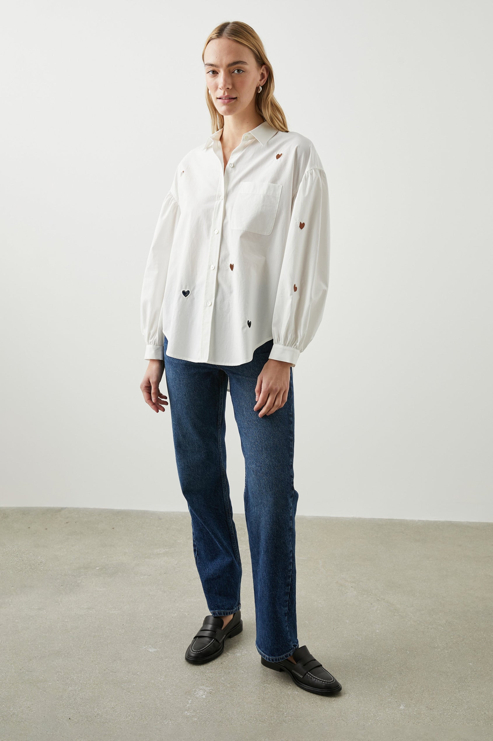 Janae Long Sleeve Button Up with a Chest Patch Pocket, Light Ruching at the Cuffs and Sleeve Shoulder and Cutout Hearts in White Eyelet Hearts Colorway - Front Full Body View Featured on Model
