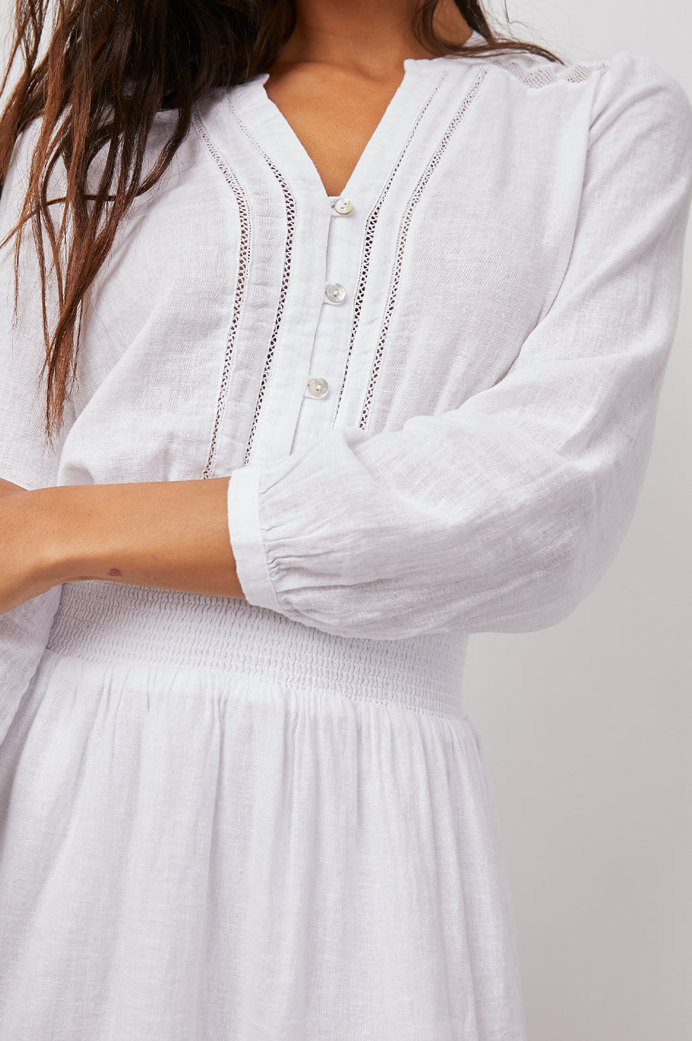 Jasmine Long-Sleeve Mini Dress with Buttons Down the Front Bodice, a Shirred Waist, a V Neck, Lace Inserts and a Double Layered Tiered Skirt in White Lace Detail Colorway - Front View Featured on Model