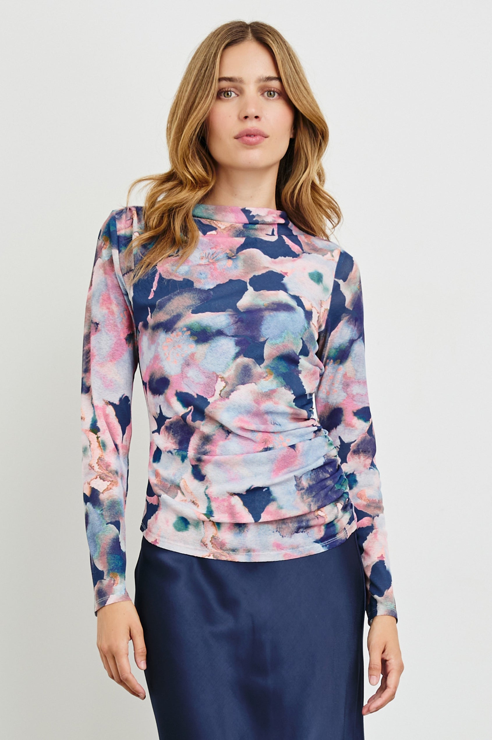 Joelle Long Sleeve Top with An Asymmetrical Mock Neck and Shirring on the Right Shoulder in Midnight Verbena Colorway, with slightly abstract flowers in pinks, purples, blues and oranges on Midnight - Front View Featured on Model