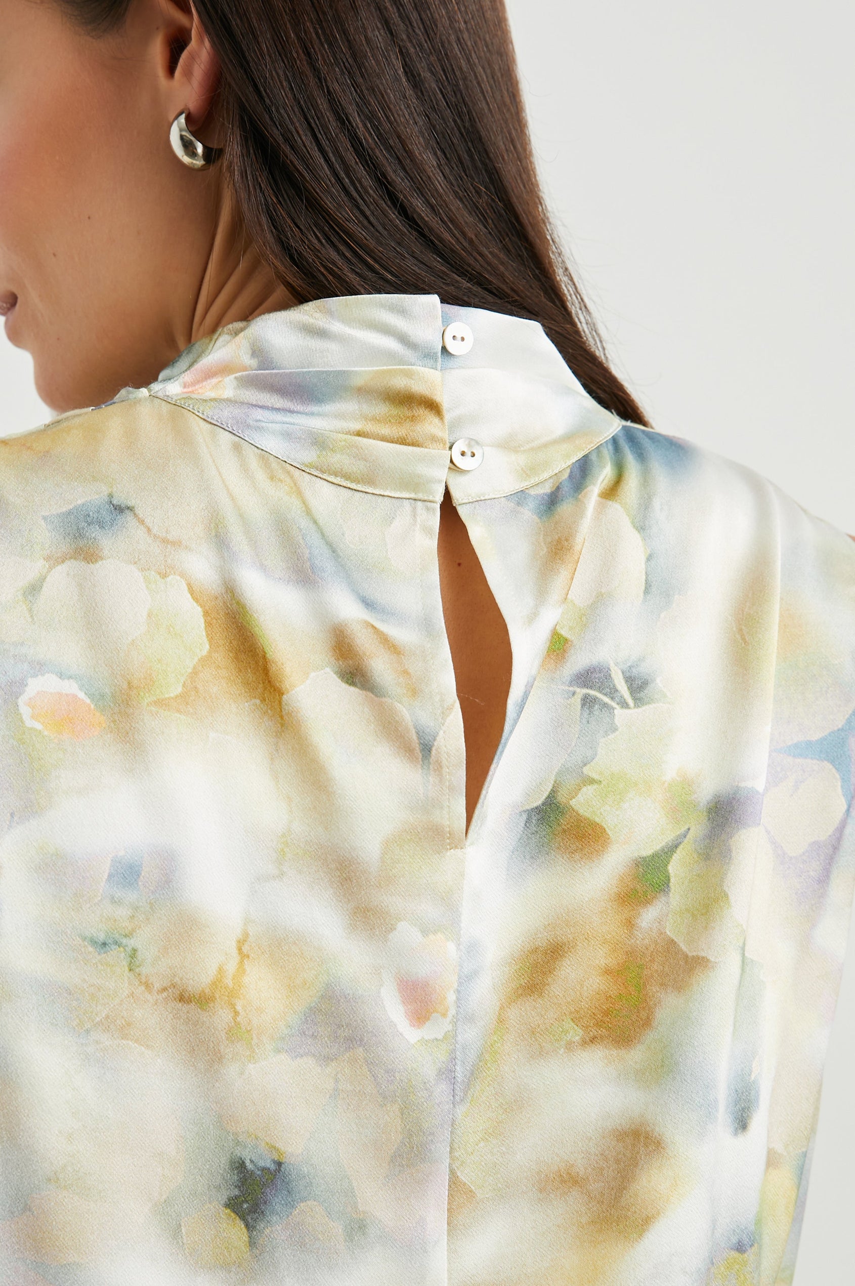 Kaleen Sleeveless Top with Mock Neck with Buttons and Keyhole on the Back and Draped Fabric on the Upper Chest in Diffused Blossom Colorway, in creams, yellows and blues - Back View Featured on Model