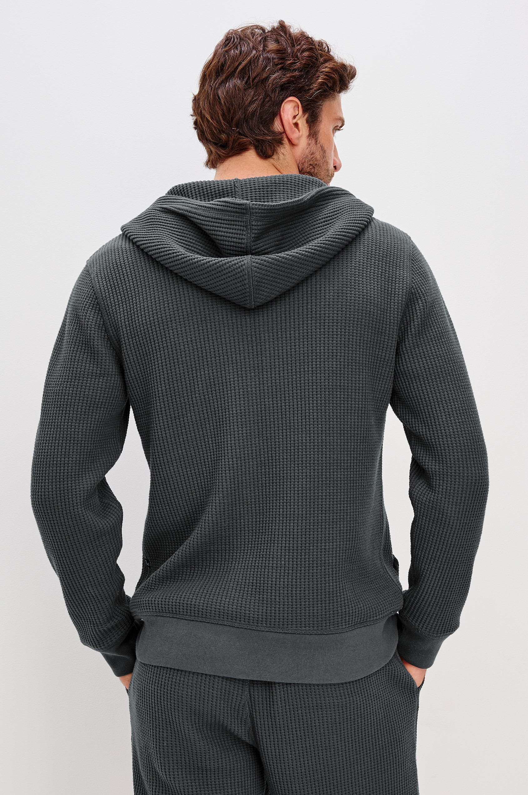 Kenton is a zip front hooded sweatshirt with front patch pockets and ribbed cuffs in Ink colorway. Back view featured on model.