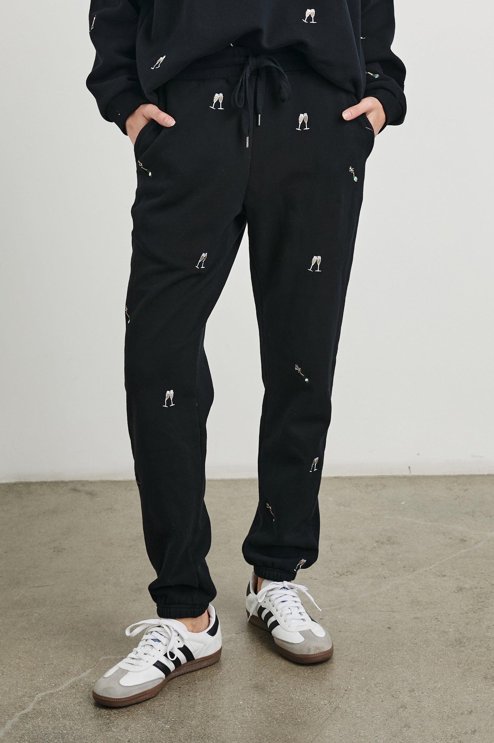 Kingston Pants with Elastic Cuffs and Waist with Drawcord in Black Champagne Embroidery Colorway, Champagne Glasses on Black - Front View Featured on Model