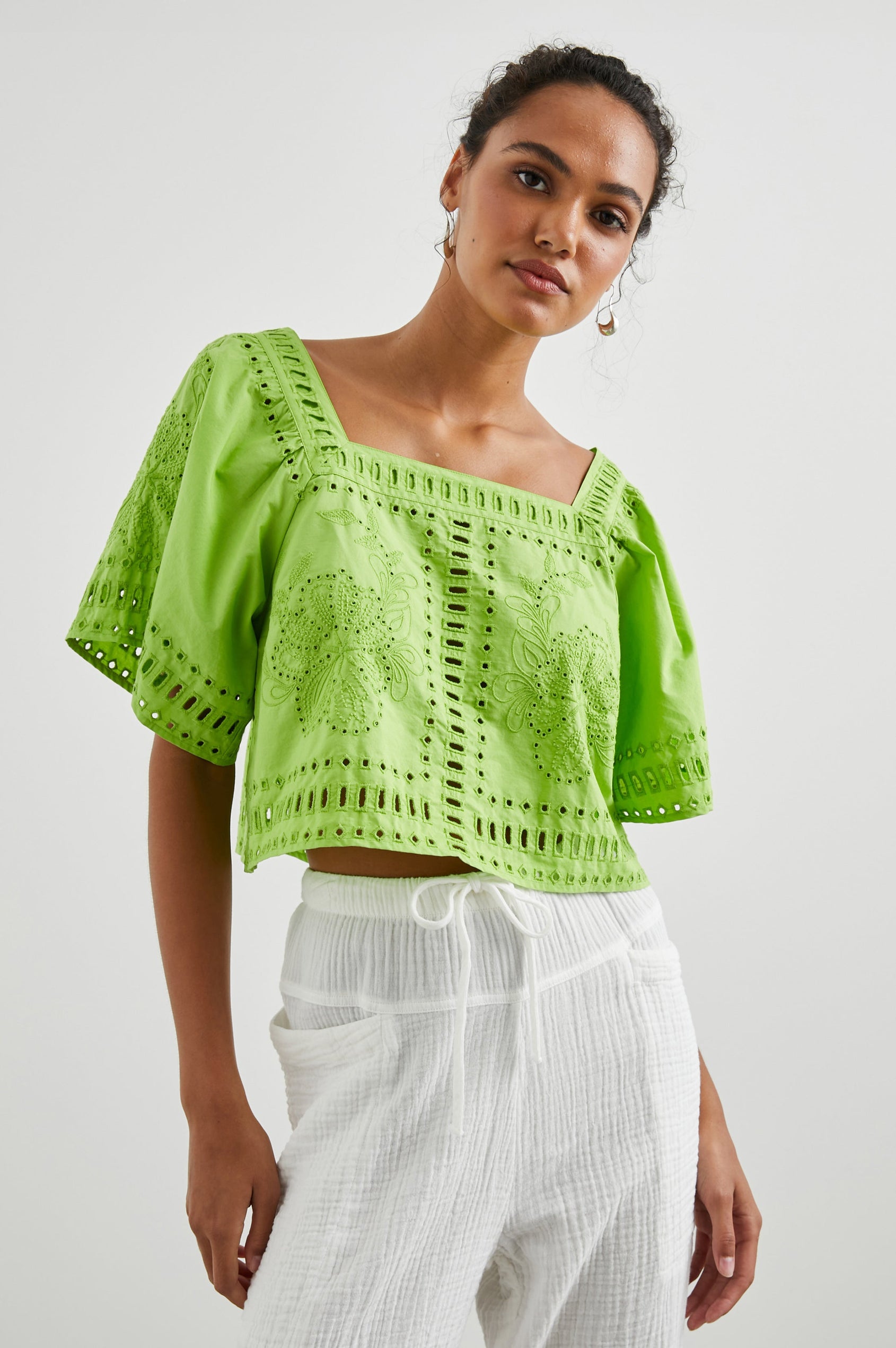 Laine Short Sleeve Crop Top with Square Neckline, and a Floral and Geometric Eyelet Design in Island Green Colorway - Front View Featured on Model