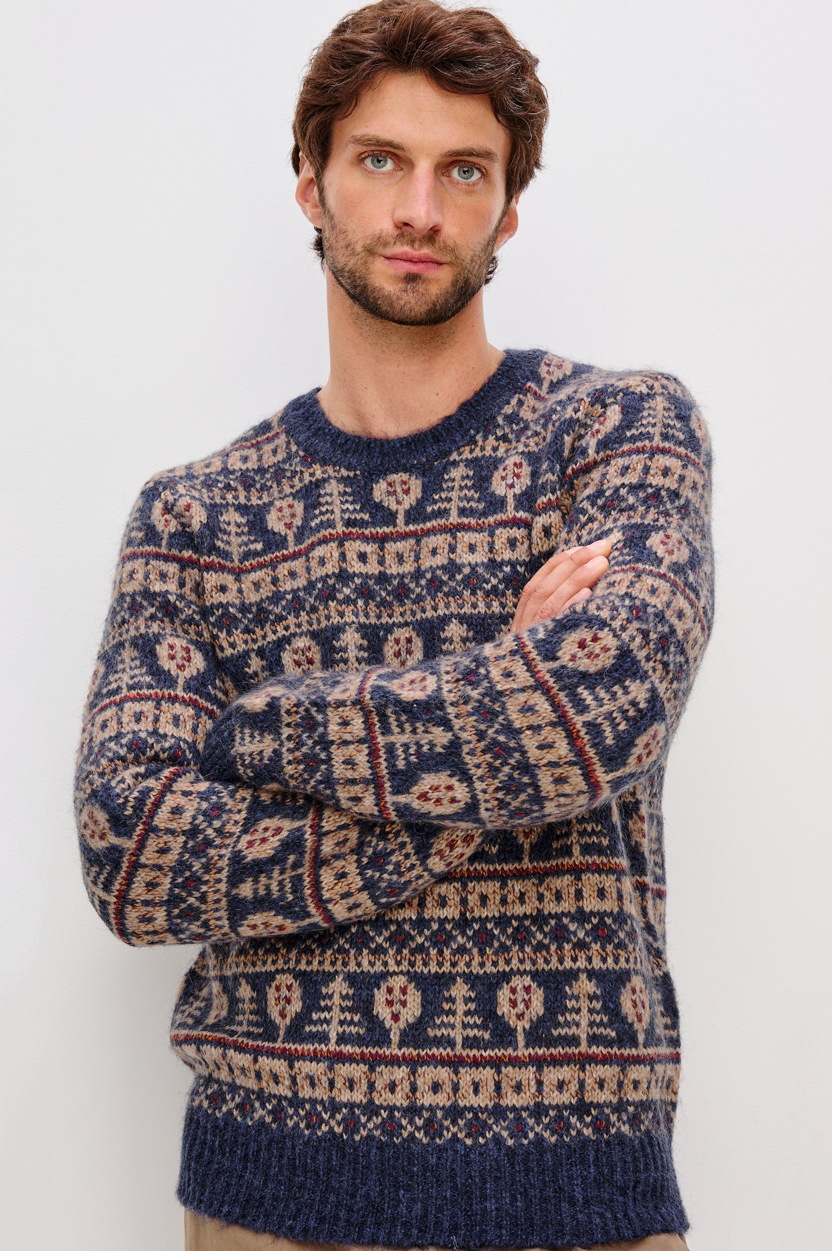 Lars is a relaxed fit crewneck sweater with long sleeves and ribbed trim, Fair Isle motifs in a merino wool blend. Front view featured on model.
